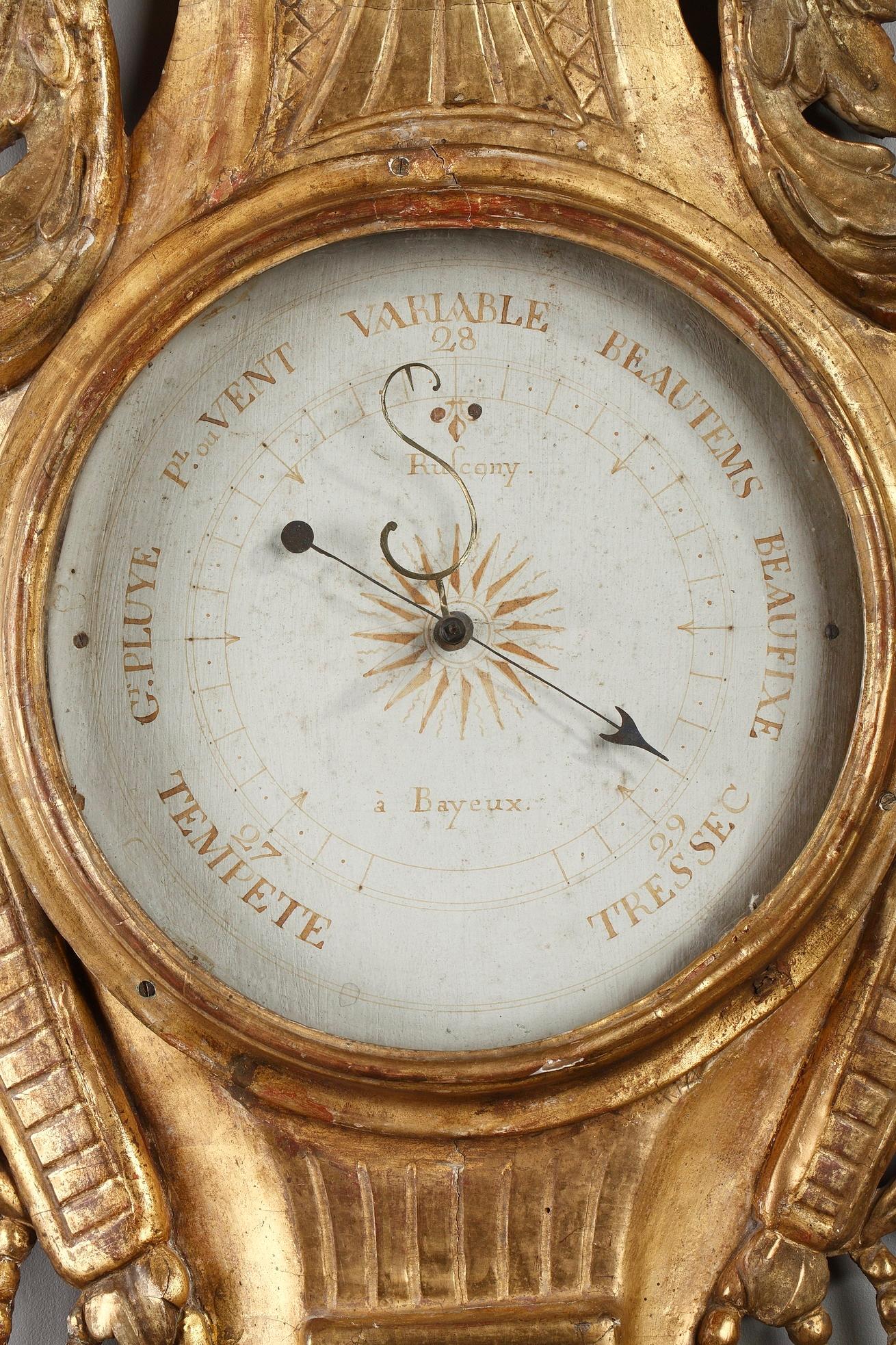 Late 18th century Louis XVI-period barometer and thermometer. The giltwood case is accentuated by flowery basket, laurel leaves and foliated scrolls. The dial marked with ink on paper, allows reading of current barometric pressure. It is flanked by