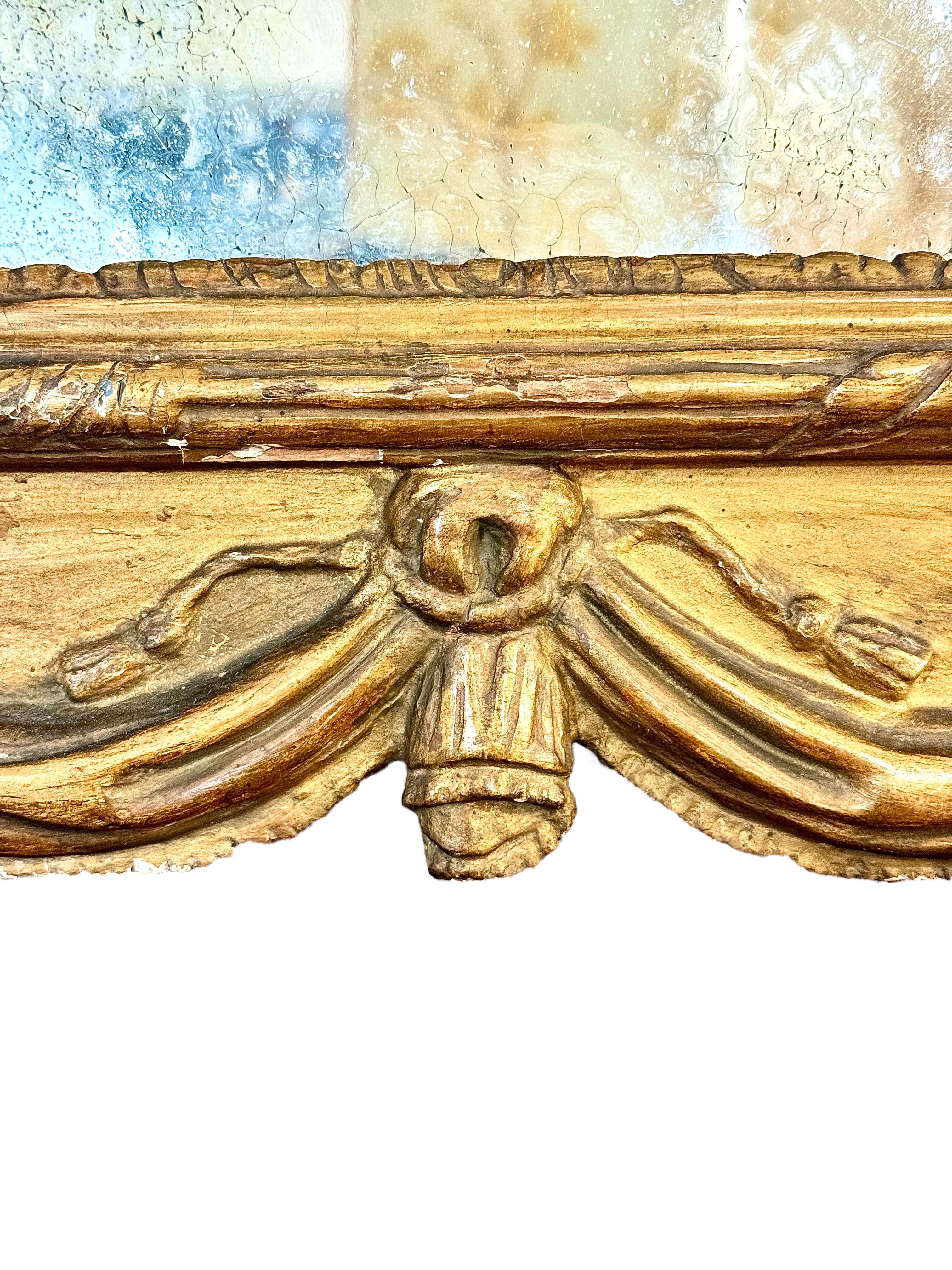 Espejo de madera dorada Luis XVI del siglo XVIII con cresta de laurel y base drapeada en Bueno estado para la venta en LA CIOTAT, FR