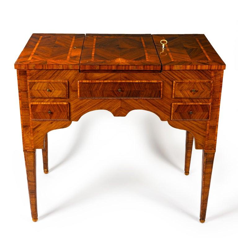 From Italy a late 18h century Louis XVI lift top lady's vanity desk, an antique walnut veneer and inlaid center rectangular dressing table, an antique Italian coiffeuse with superlative marquetry, shaped aprons on each side, resting on tapered legs,
