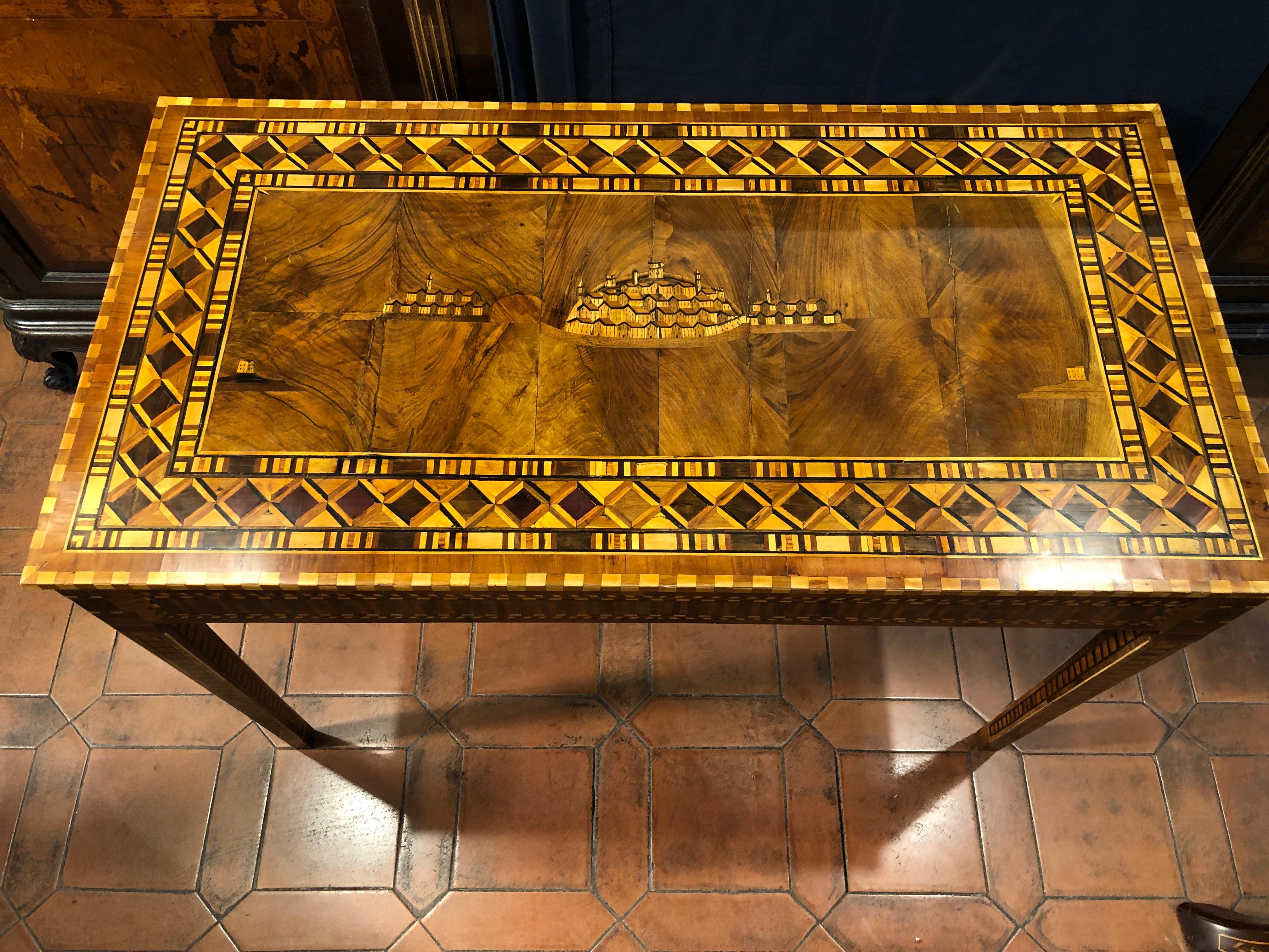Rare console table of Italian origin, school of Sorrento inlay, we find geometric figures on the floor and legs and in the center an inlay that should represent Positano. Period Louis XVI, circa 1780.
In walnut wood and inlaid with fruit woods.