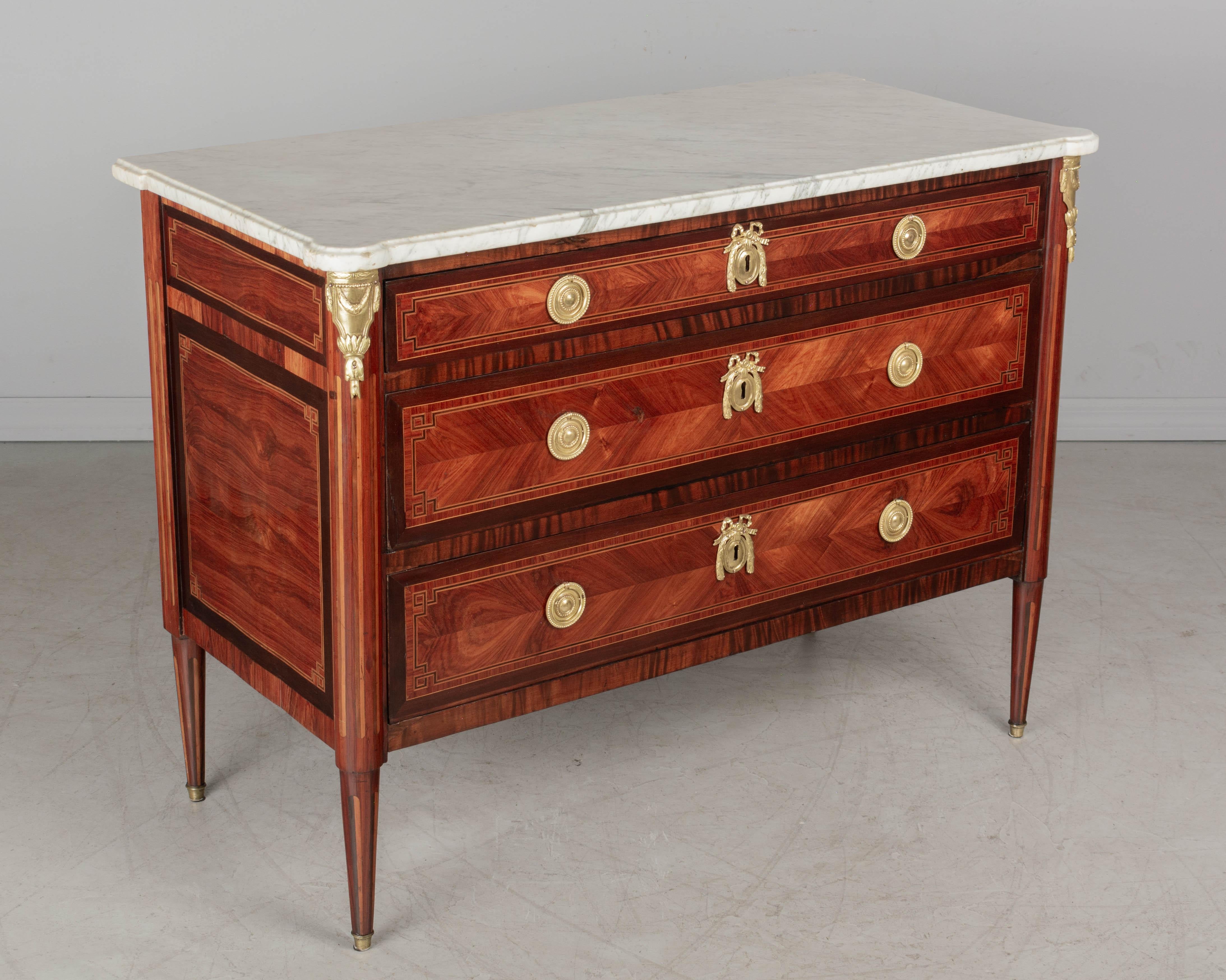 A fine 18th century French Louis XVI marquetry commode, expertly crafted by master ébéniste Jean-Baptiste Lependu from solid oak secondary wood with tulipwood, kingwood and satinwood veneers, and original shaped white veined marble top. Three