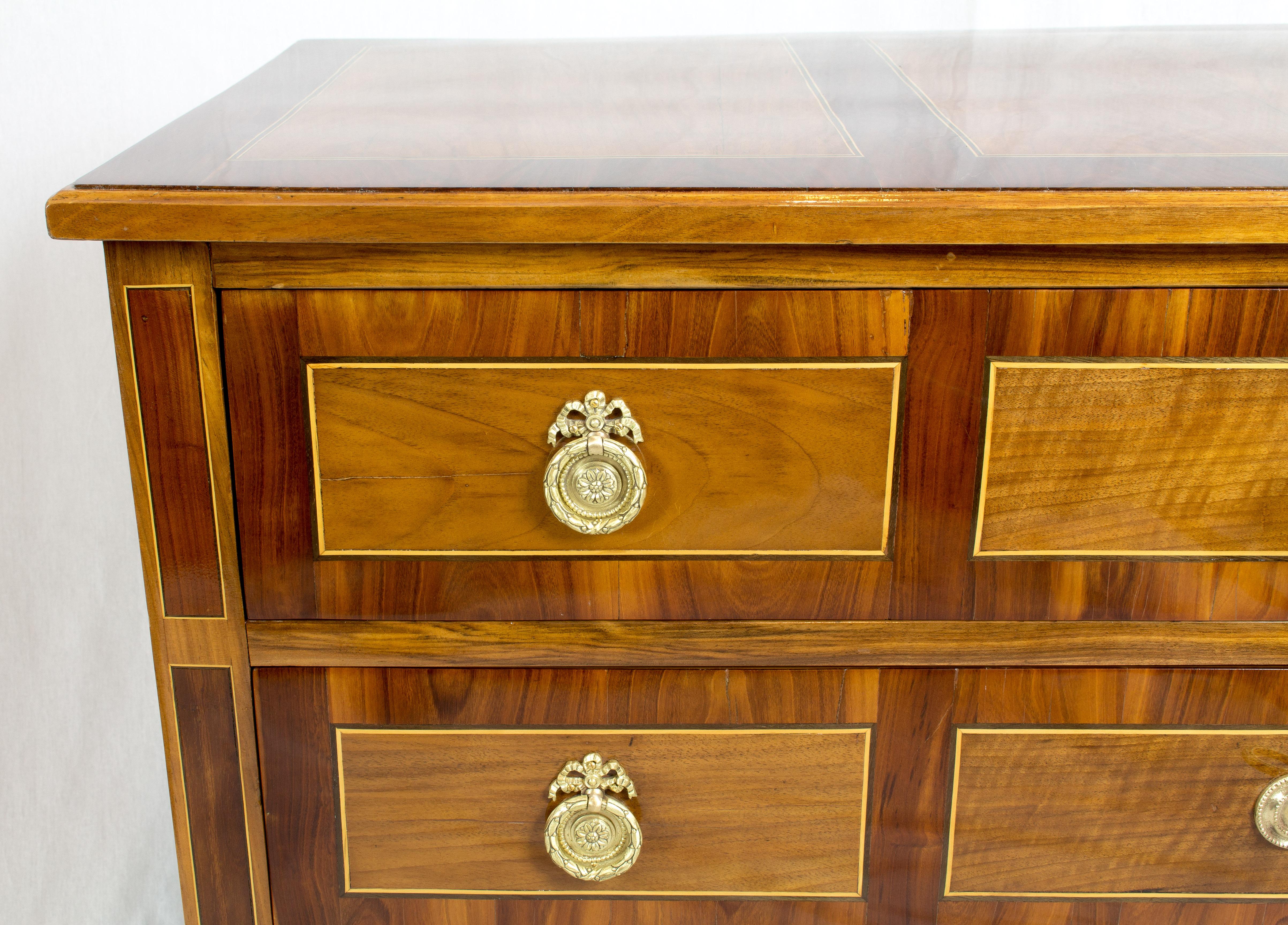 An 18th century Louis XVI marquetry commode with three drawers was built in France. The veneers of walnut and nutwood and ribbon inlays with lime wood and black bog oak on a spruce wood corpus. The sides are made of solid walnut. All locks, fittings