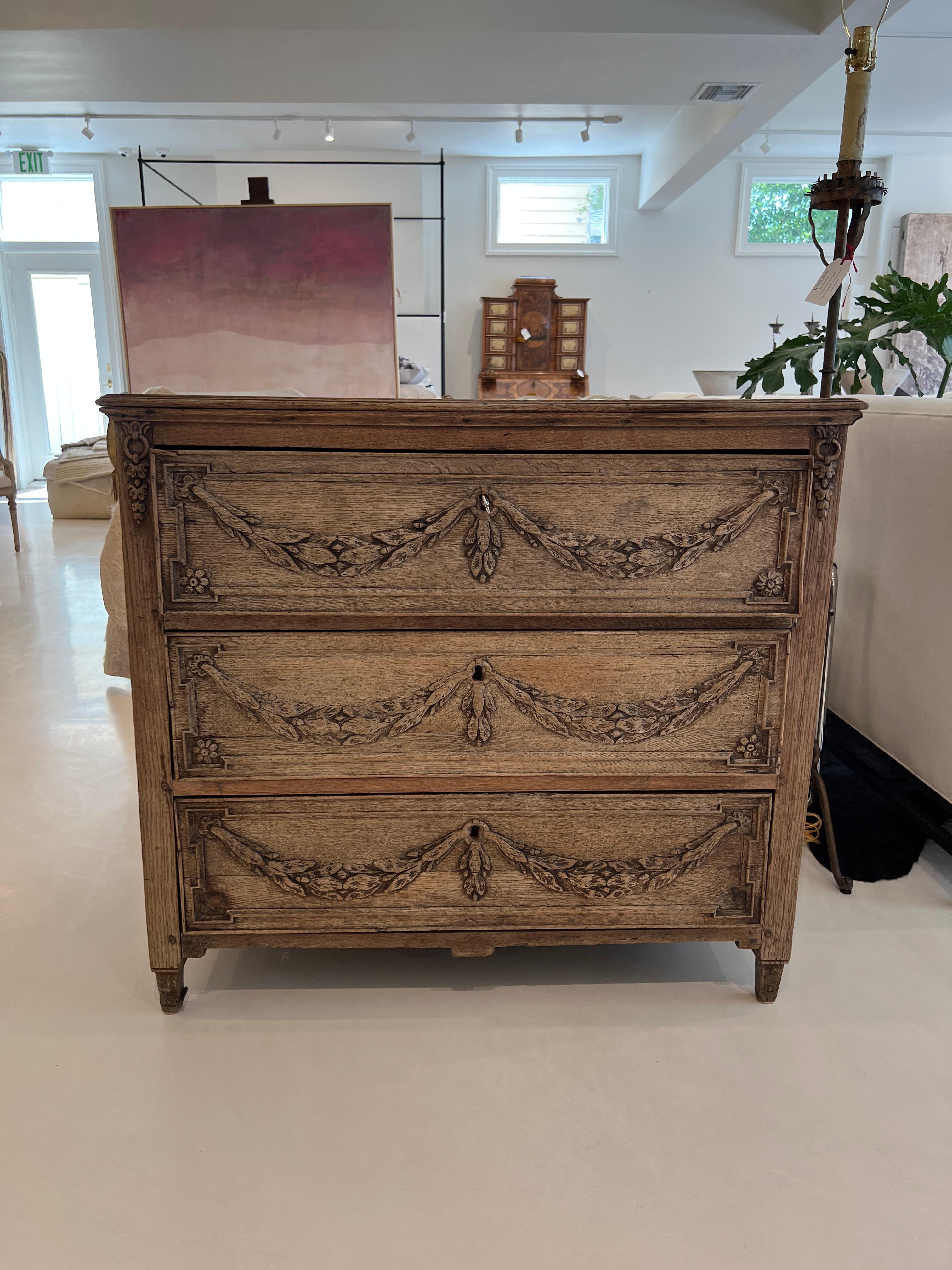 This chest is arrestingly beautiful due to the gentle carving of garlands and flowers on the drawer fronts. Perfectly symmetrical design on beautiful raw oak. Another fine feature is the depth of the top.