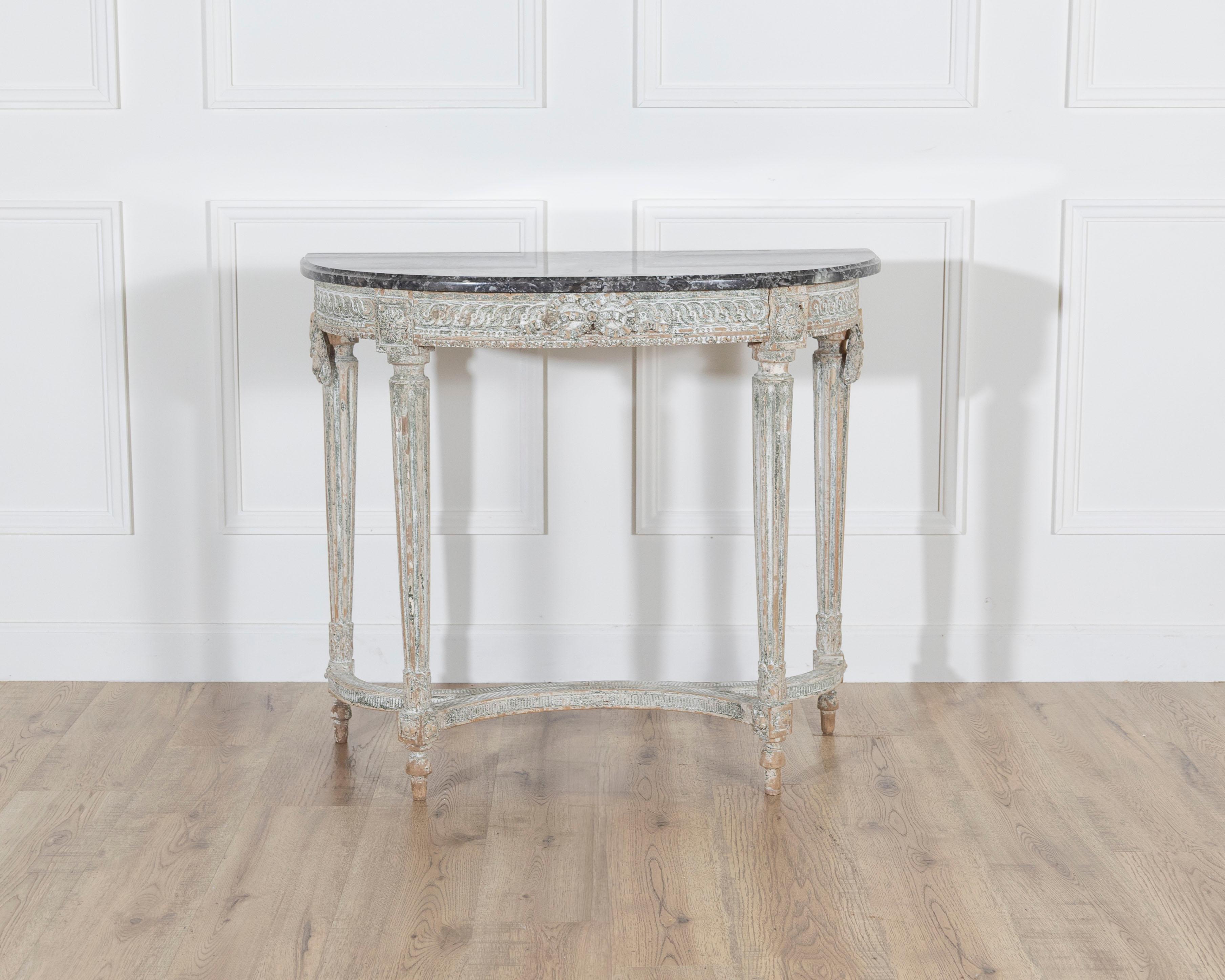 Elegant 18th-century French Louis XVI period console table with four legs, crafted in carved wood and retaining its original painted finish. The table features refined neoclassical details including fluted legs, floral motifs, and delicate beaded