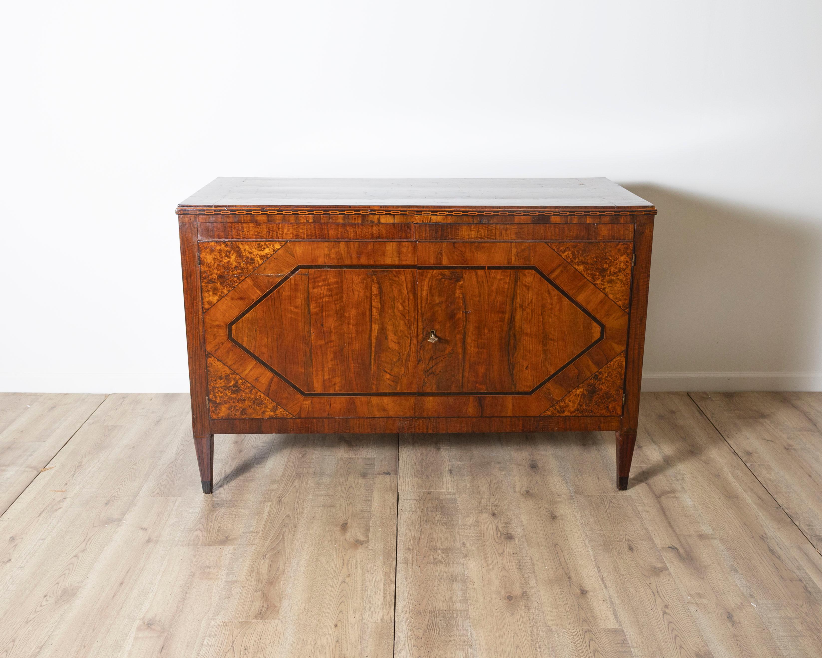 A refined and architecturally balanced Italian sideboard from the Louis XVI period, expertly crafted in walnut and various fine woods with intricate inlays. The piece is distinguished by its geometric elegance, featuring a repeated octagonal motif