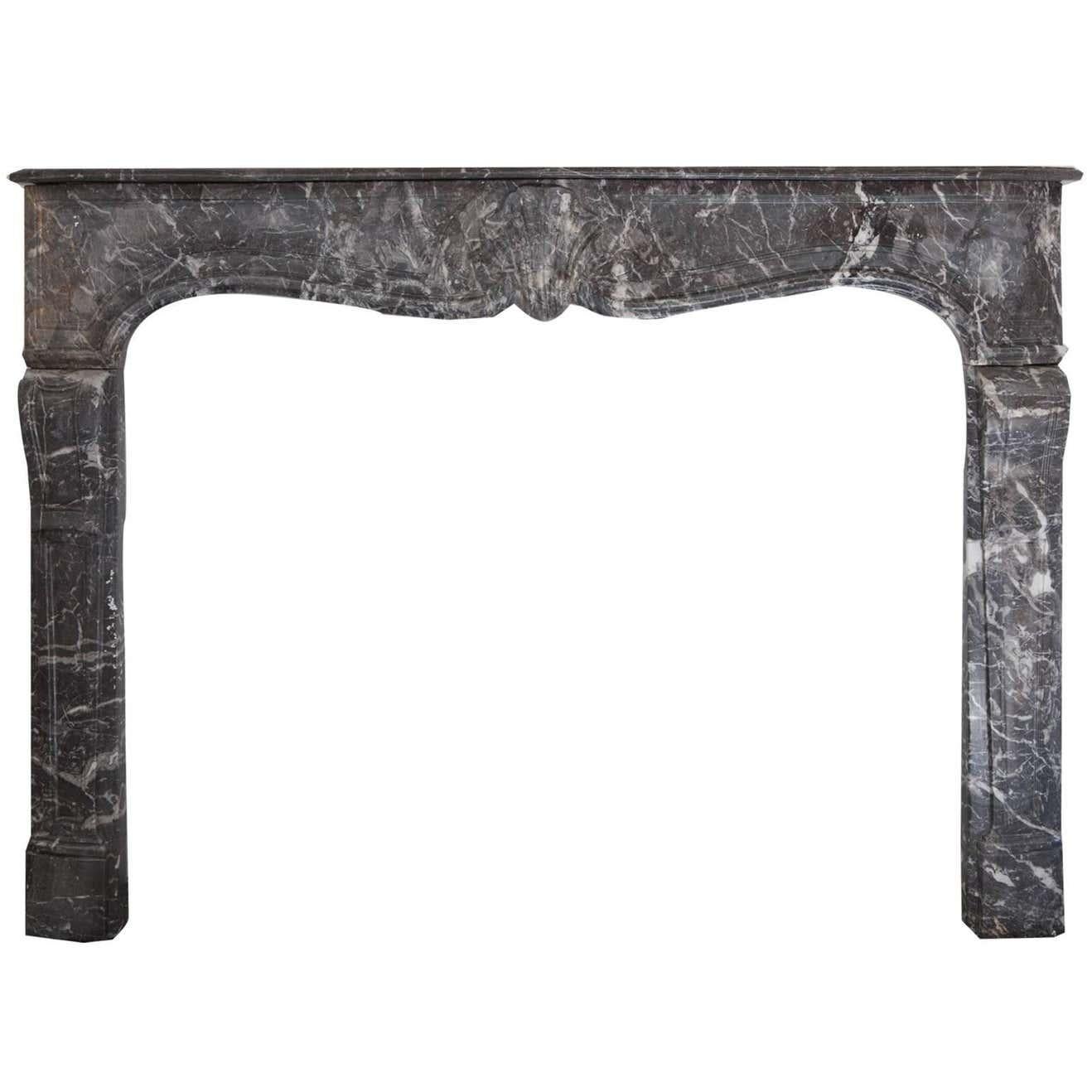 Rare cheminée française Louis XVI du XVIIIe siècle. Sculpté à la main dans le marbre de St Anne. Les jambages et la frise sont délicatement sculptés et la coquille centrale est élégamment sculptée, ainsi qu'une étagère moulée et détaillée.