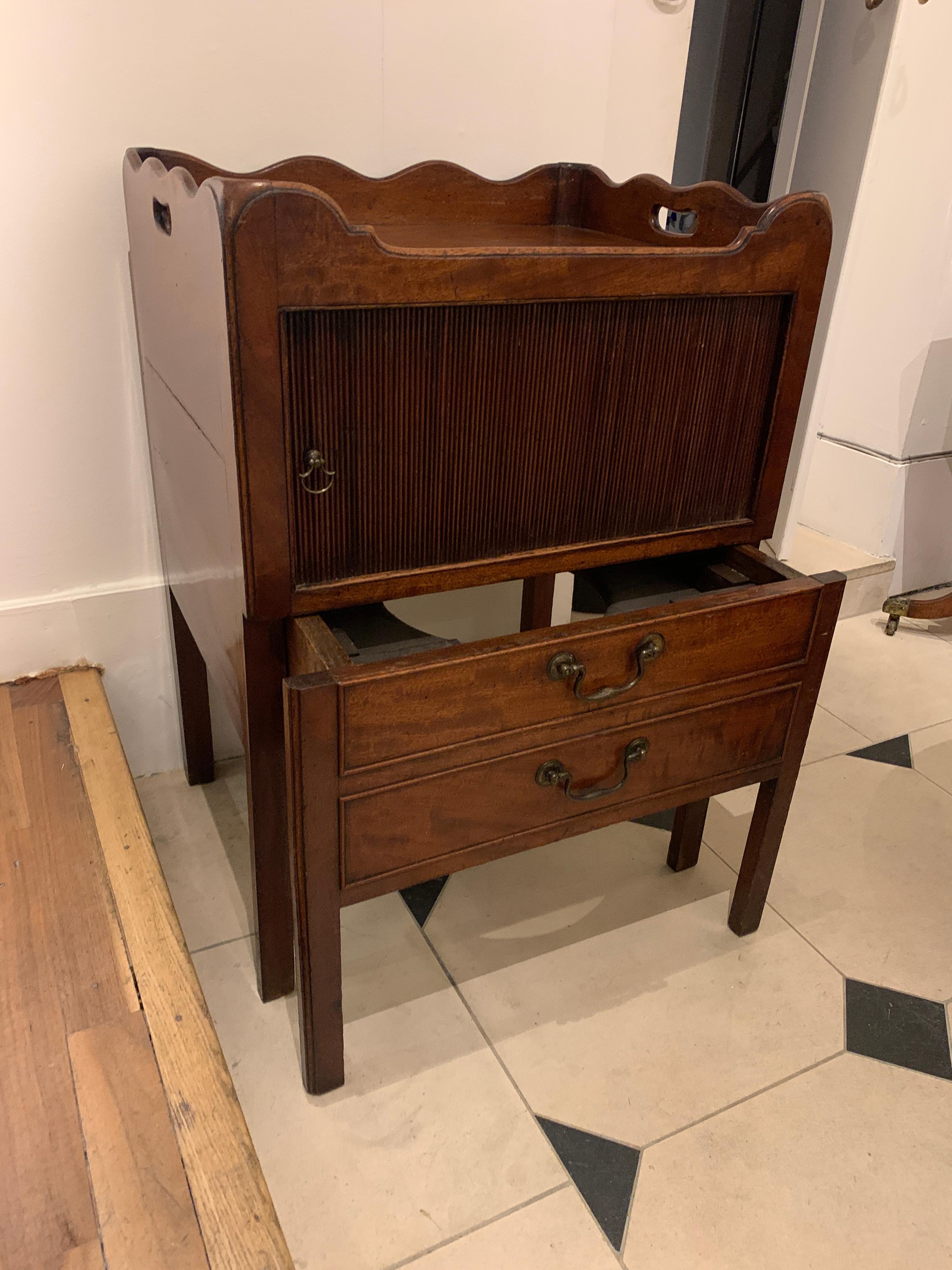 A mahogany bedside cabinet/commode with a tray top and sliding tambour door, above two drawers with brass handles,

circa 1780

Measures: Height 79cm
Width 55.5 cm
Depth 45.5 cm.
  