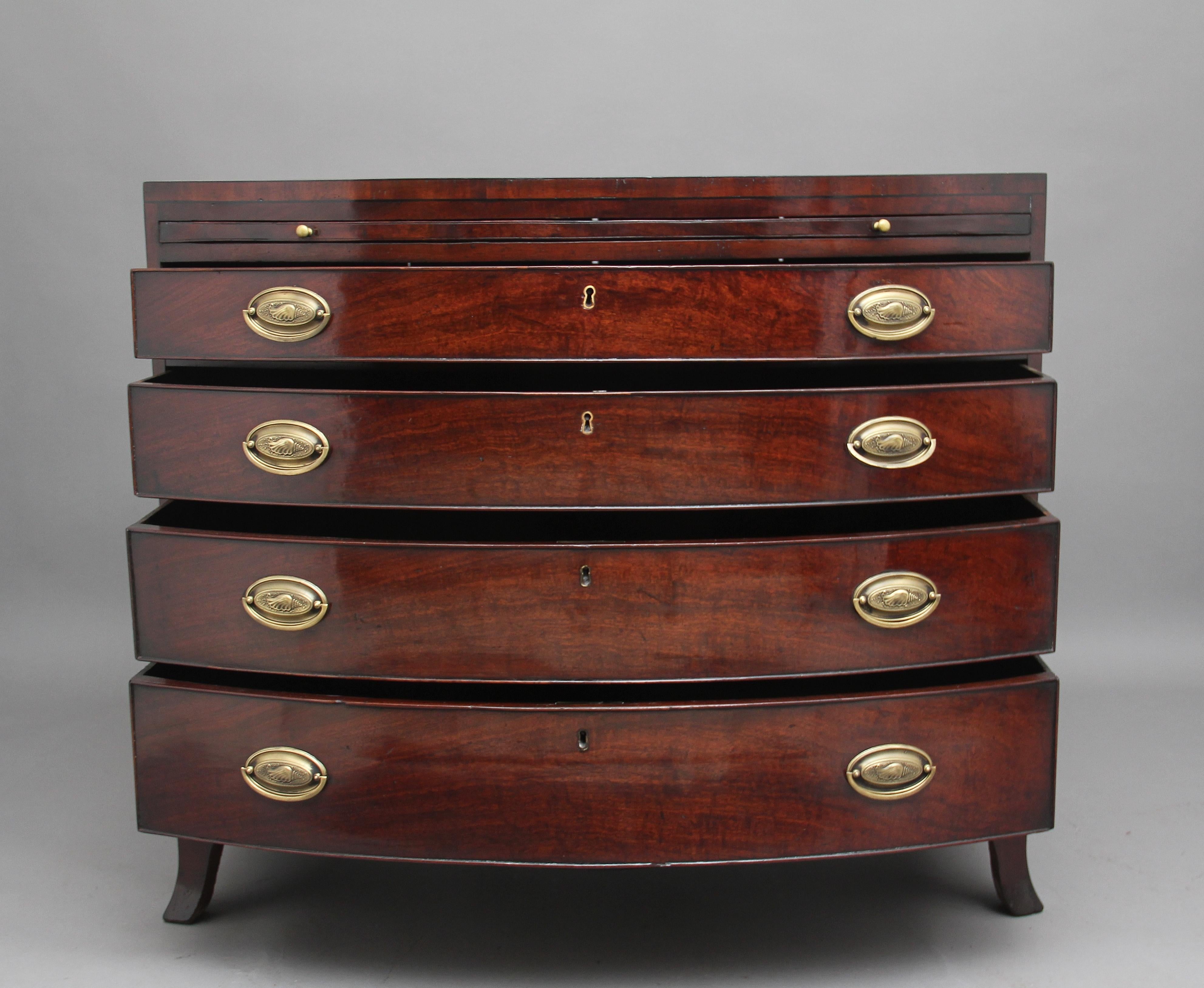 18th century mahogany bowfront chest of drawers, the crossbanded top having a brushing slide below, four graduated, oak lined drawers with brass oval handles, shaped frieze running along the front and sides of the chest, standing on splay feet.
