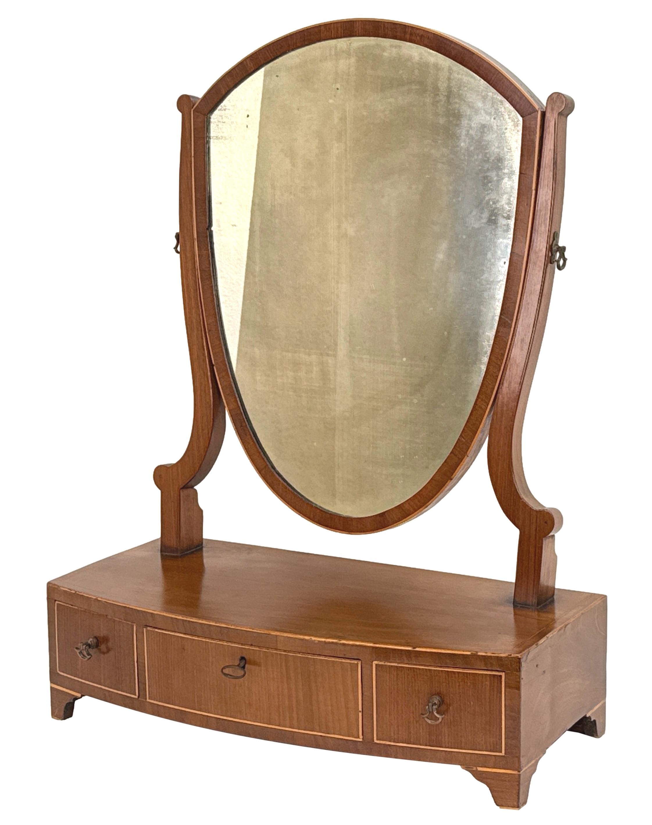 A Very Good Quality Late 18th Century, George III Period, Mahogany Dressing Table Mirror, Having Old Shield Shaped Swing Plate, Over Elegant And Well Figured Bowfront Base, With Three Drawers To Frieze, Raised On Original Splay Bracket Feet.

Often