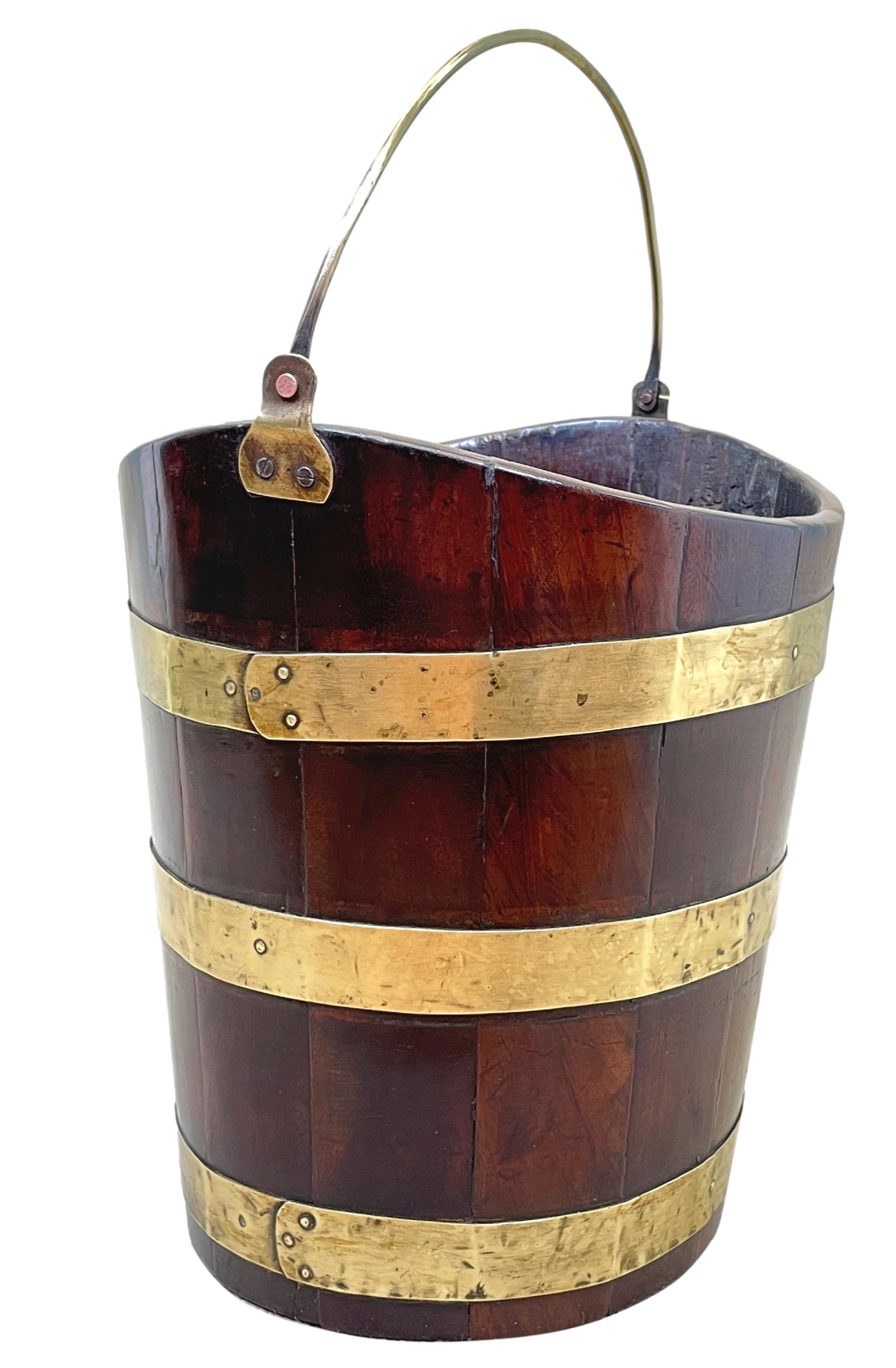 A very attractive 18th century Georgian mahogany oval bucket having original brass loop swing handle and elegant brass bound decoration. 

Circa 1770. 

Measures: height 13in. 
Width 12.5in. 
Depth 10.5in.