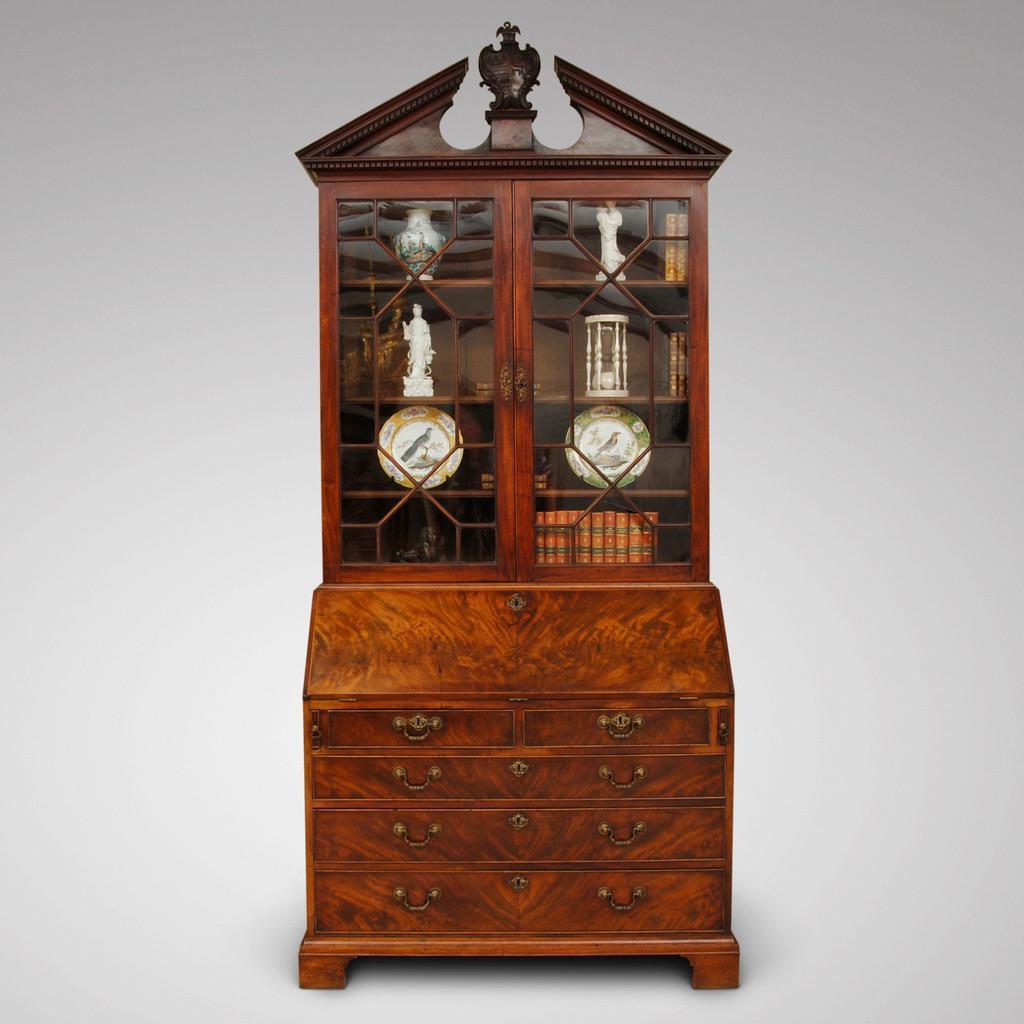 An early George III period mahogany bureau bookcase. The drawer fronts and fall butt finely veneered, the fall front opens to reveal a well fitted interior. The glazed top section has a superb broken arch pediment with dog tooth mouldings and a