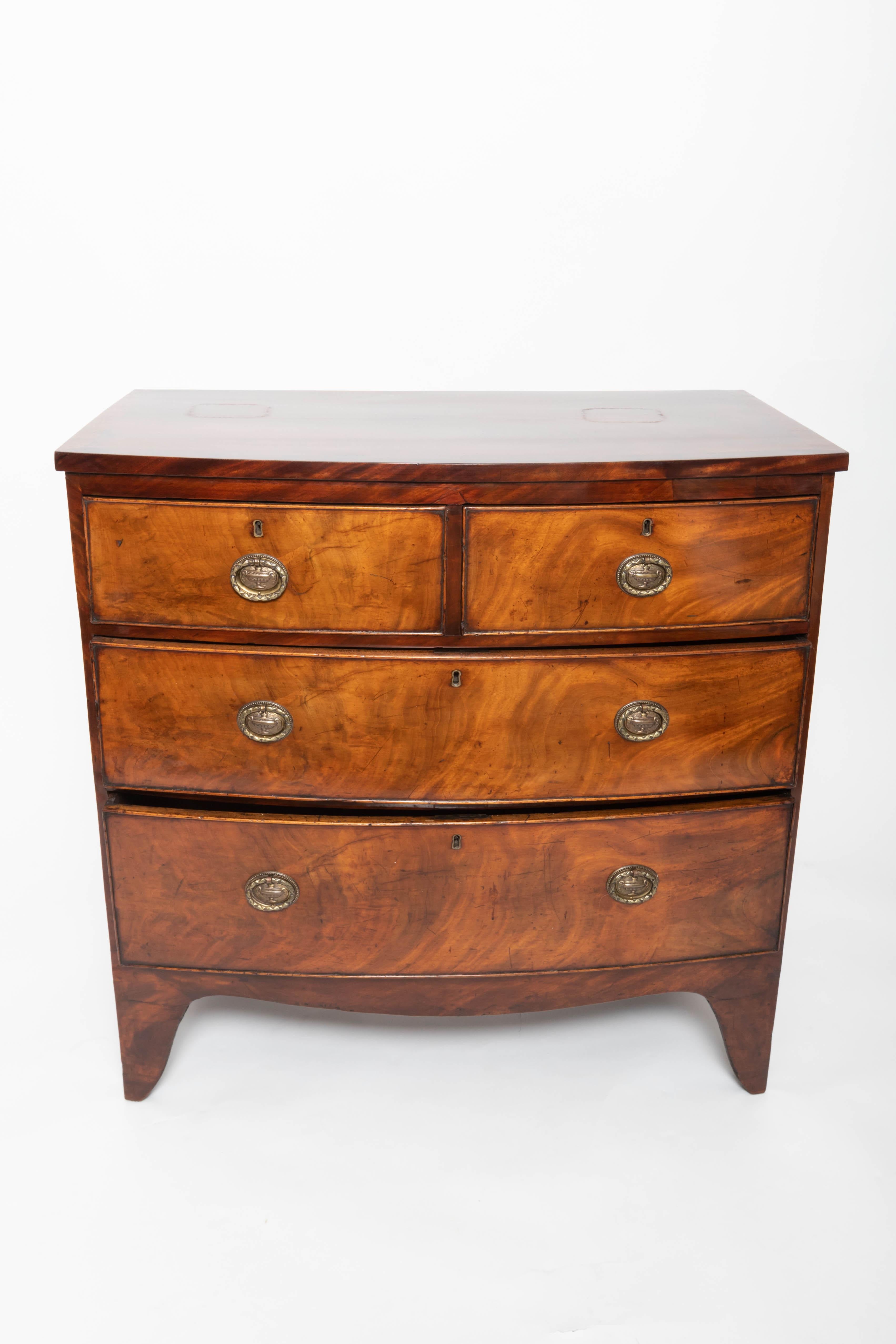Georgian chest of drawers, two short drawers over three long shaped apron, brass pulls, banded edge on top, splayed feet, wonderful graining.