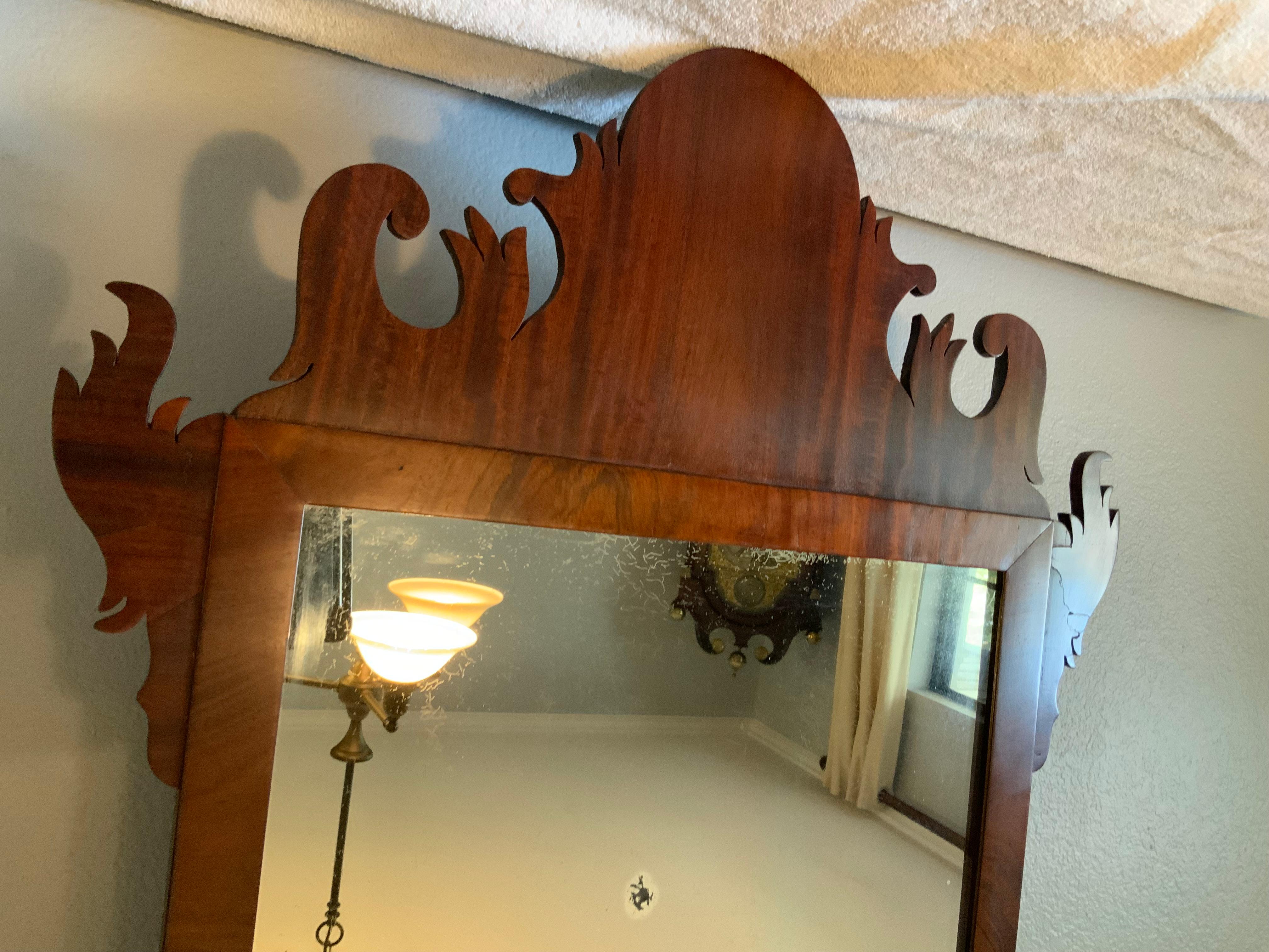 A very attractive late 18th century Mahogany Chippendale mirror. Exceptional fretwork cutouts.  Early glass has imperfections and appears to be the original backboards on most of the back.  Large top and bottom pieces of the Mahogany are slightly