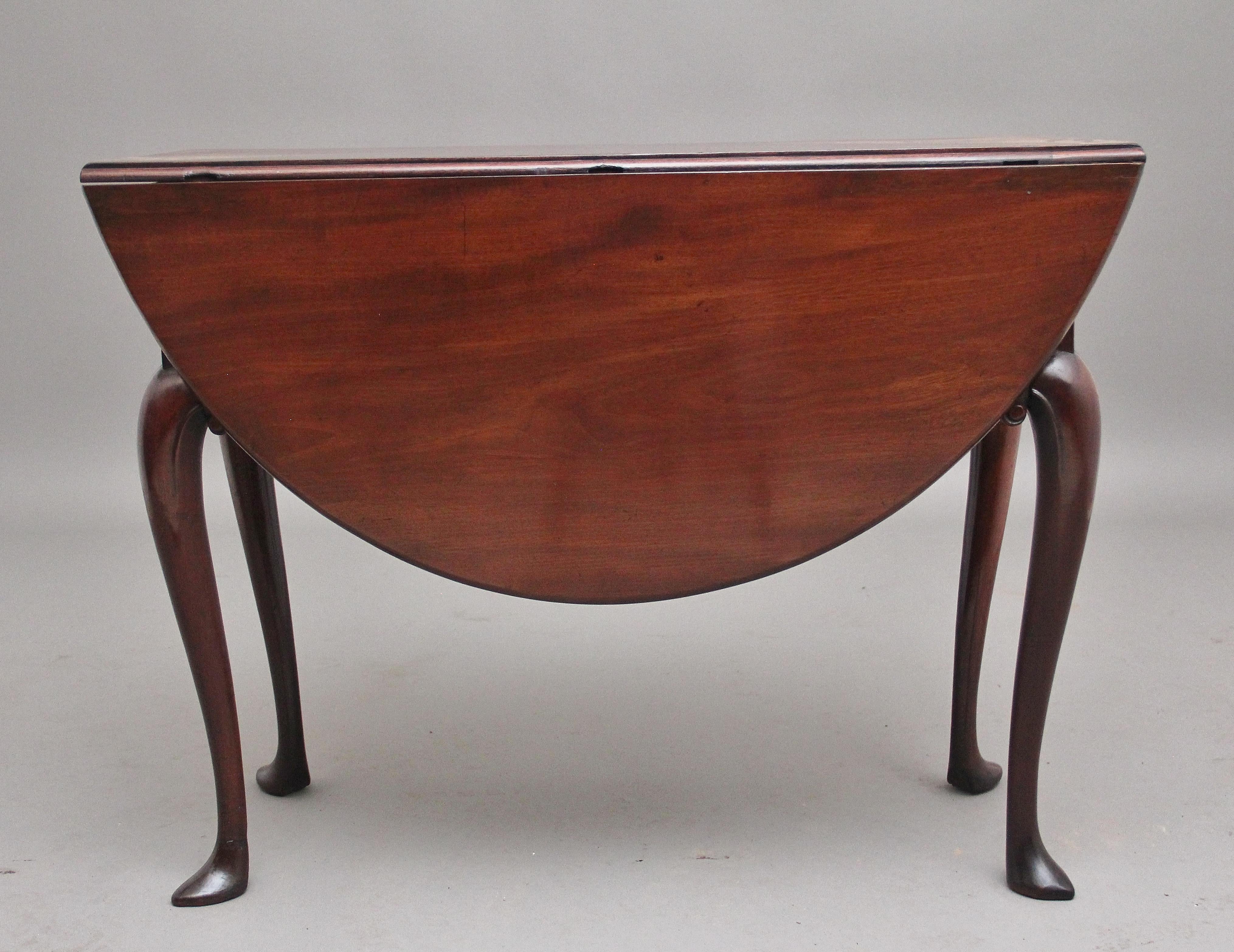 18th century Georgian mahogany drop leaf table, having a lovely figured solid top, once the leaves are fully extended the top is oval in shape, standing on elegant cabriole legs with carved scroll decoration, having a lovely warm rich mahogany