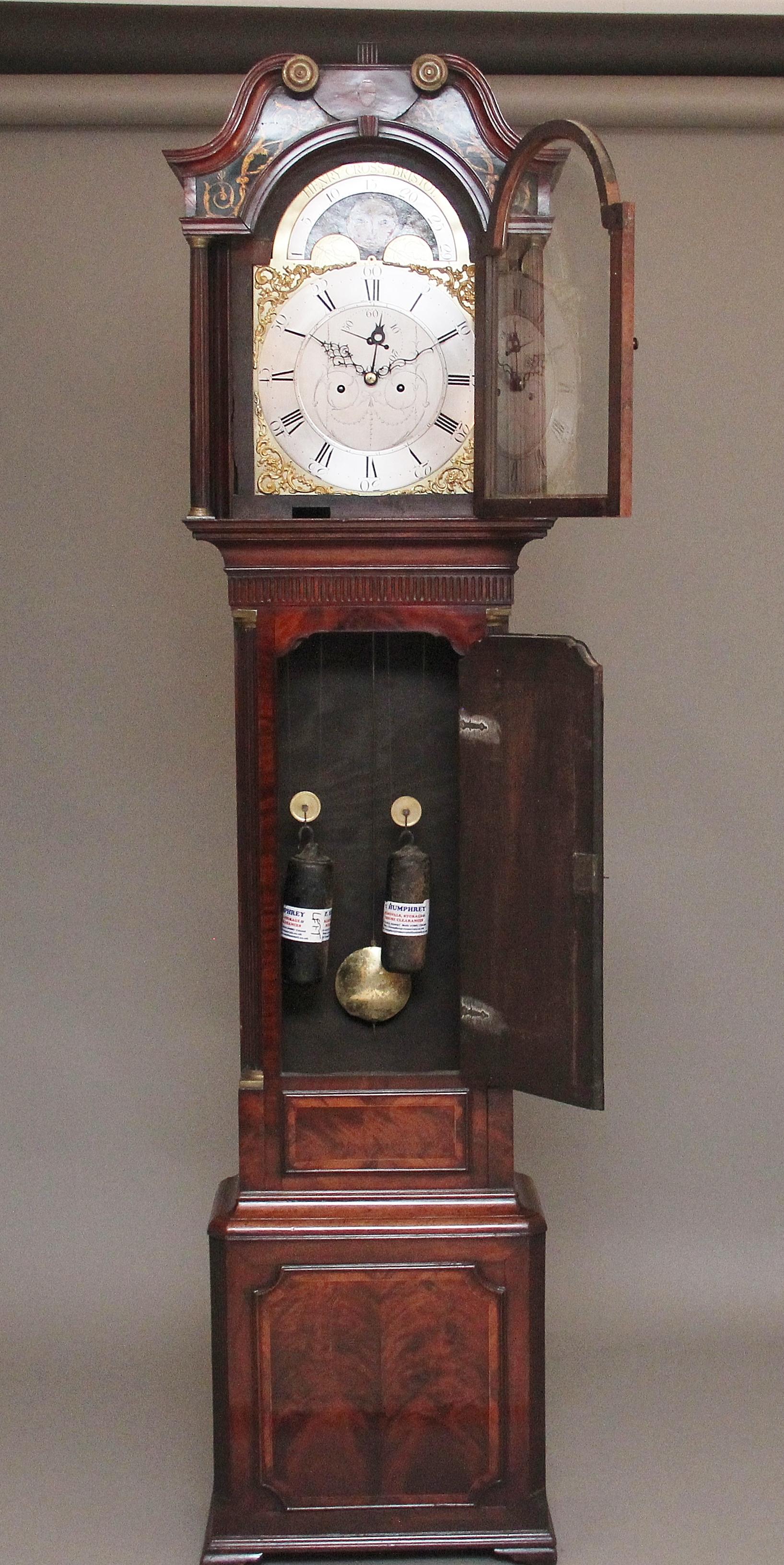 18th Century mahogany eight day long case clock by Henry Cross of Bristol, having a silvered dial arched clock face with a seconds dial, moon roller and calendar, striking on the hour, the movement has been fully restored and cleaned. The clock hood