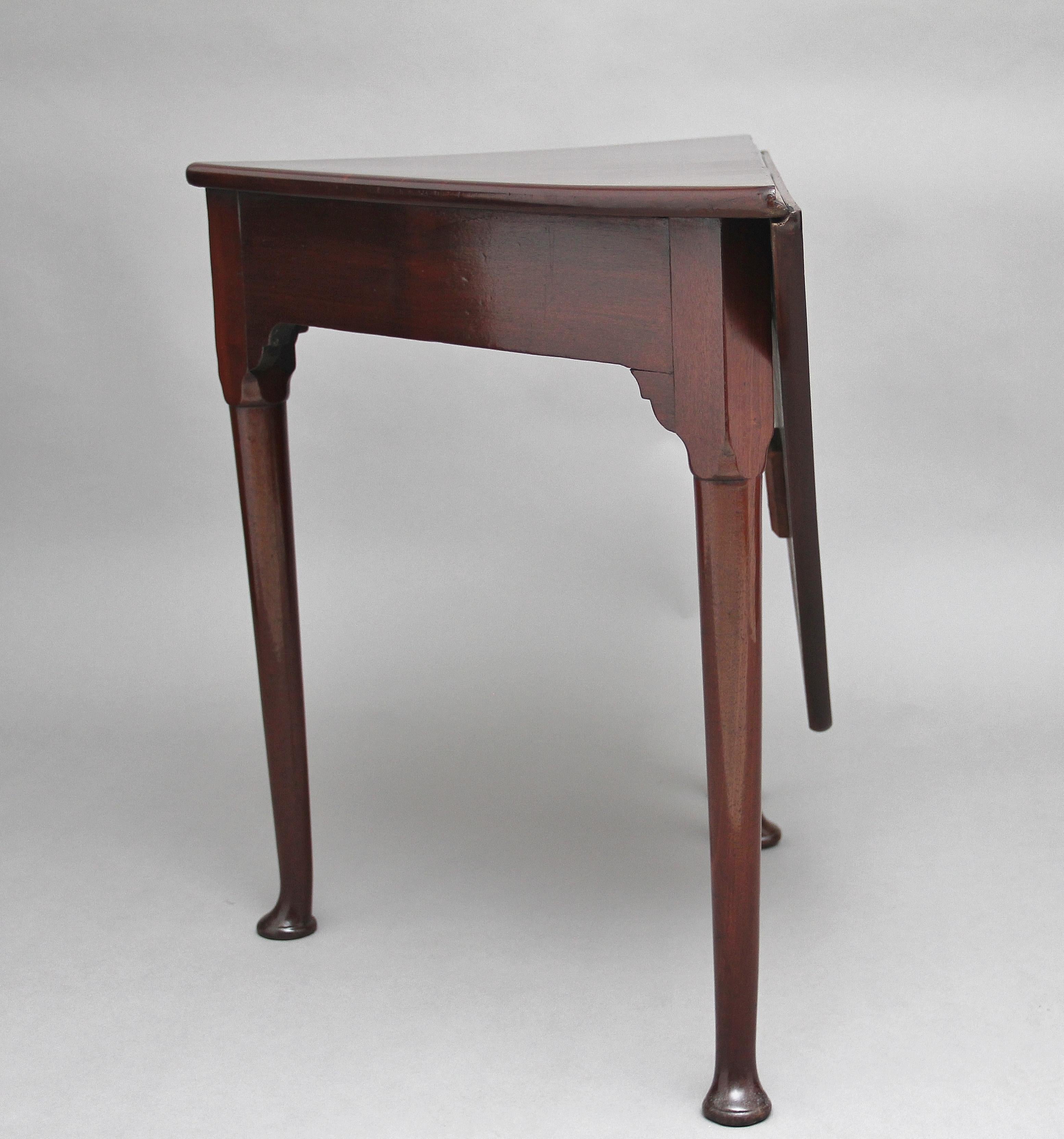 18th century mahogany envelope / corner table with a triangular top, the drop leaf section lifting up forming a square top, supported on four turned legs with a pad foot, circa 1780.