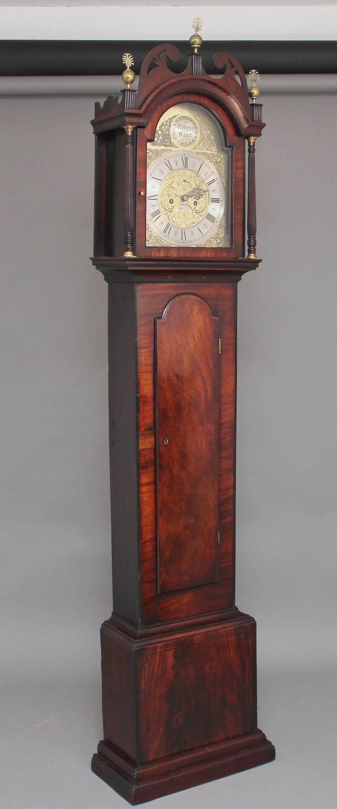 18th century mahogany long case clock by Thomas Elliott of London, it has an arch dial with a brass face and silvered chapter ring, the hood has turned and fluted columns either side of the door with brass capitals, the hood also has a lovely shaped