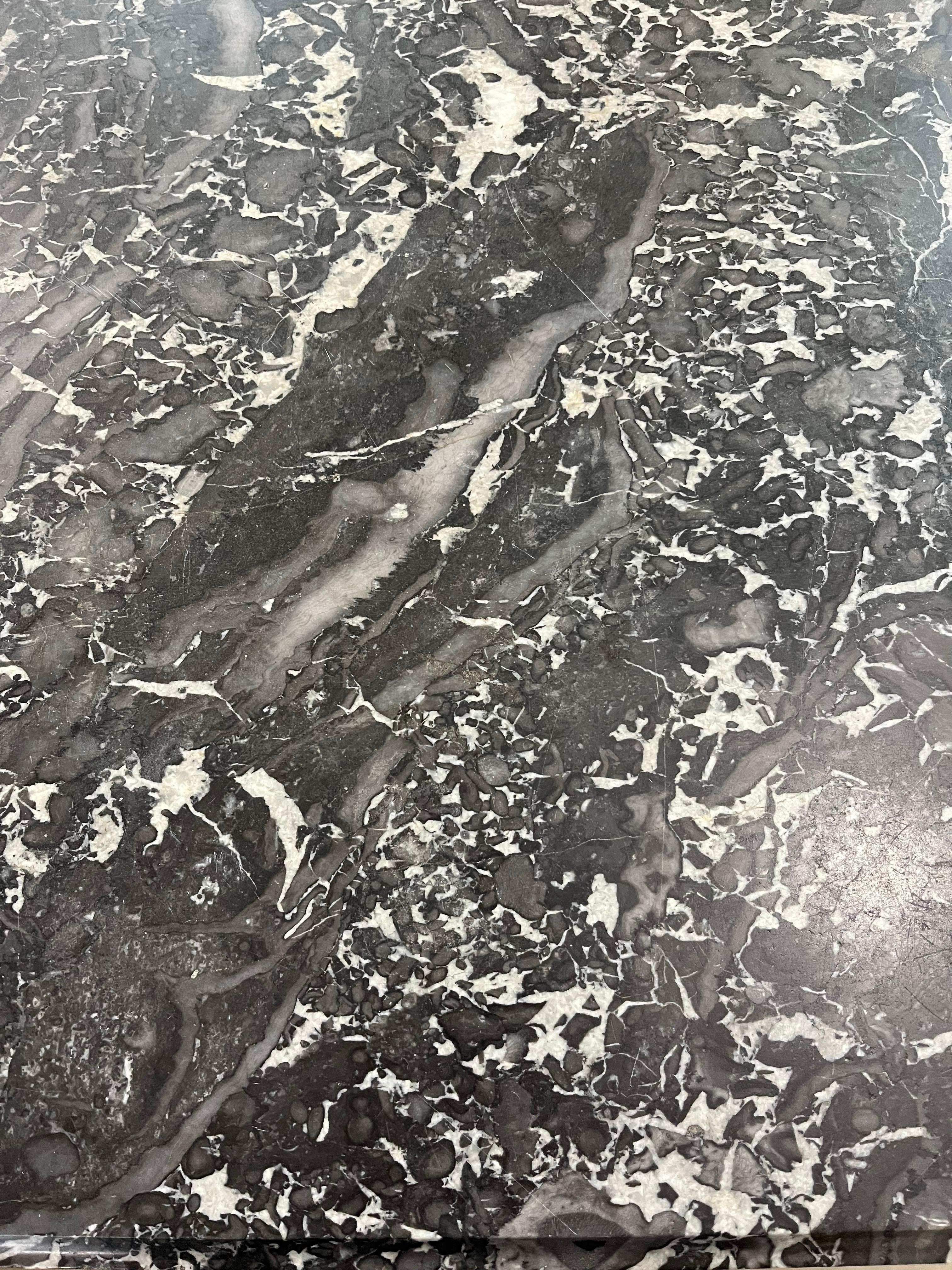 Commode fabriquée à la main en France à la fin des années 1700 en acajou et en marbre gris. La commode comporte trois tiroirs encastrés montrant de magnifiques joints à queue d'aronde faits à la main et décorés de moulures sculptées à la main et