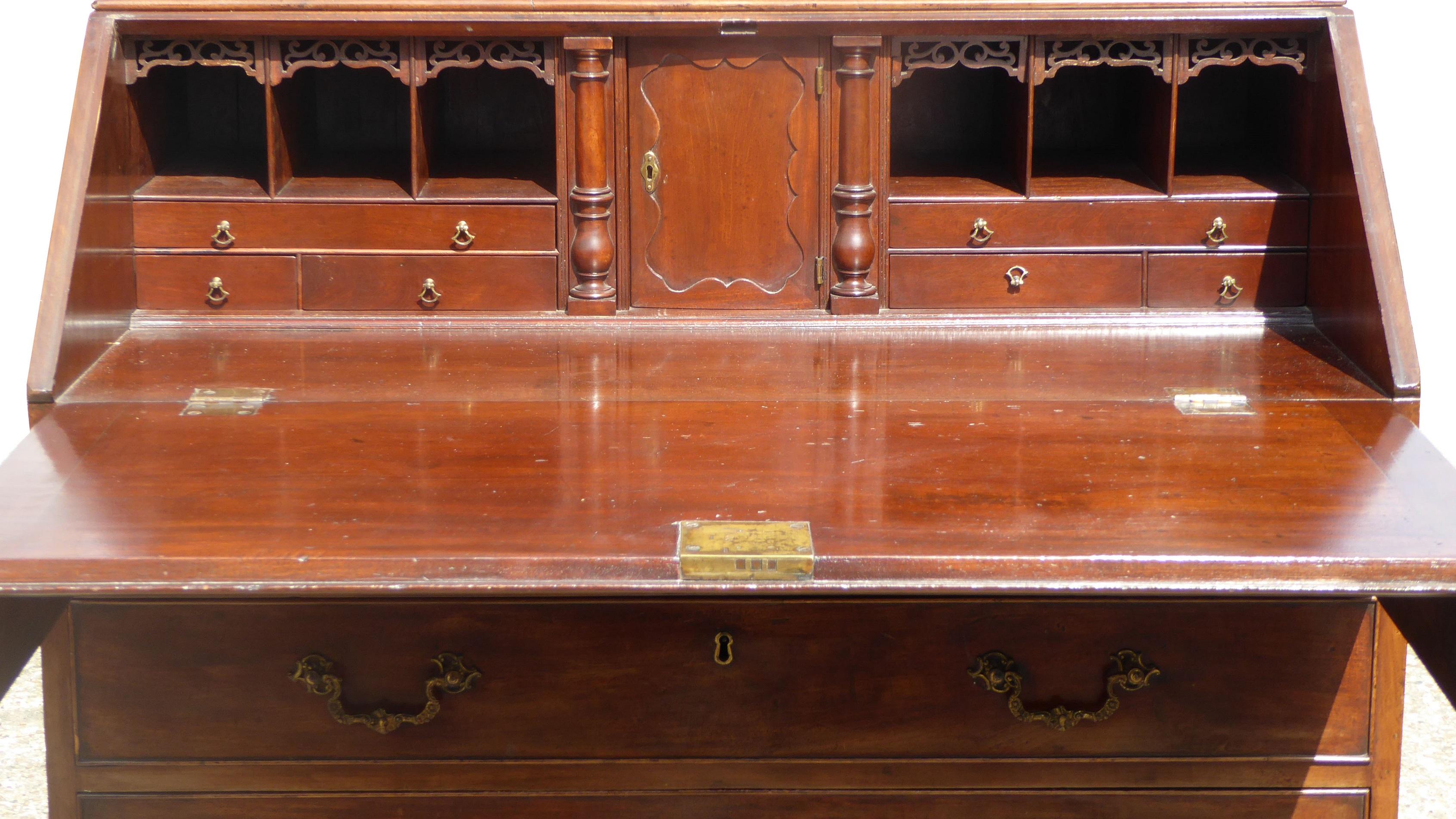 For sale is a good quality George III Mahogany Bureau Bookcase. The top of the bookcase has an ornate pediment above two glazed doors, opening to reveal adjustable shelves. Below this is the bureau section, with the fall front opening to reveal a