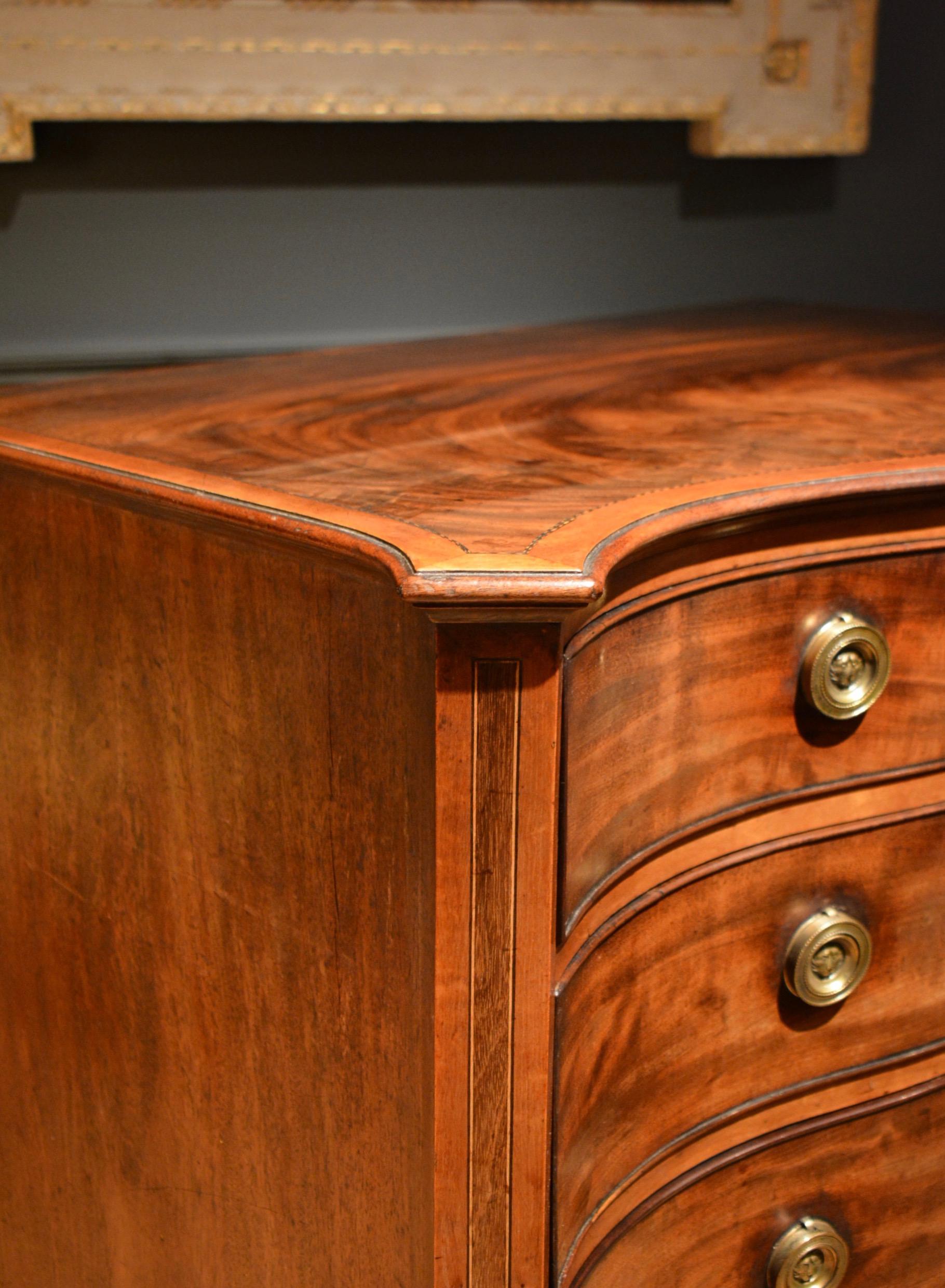 A George III mahogany serpentine four-drawer chest of drawers, banded in satinwood.