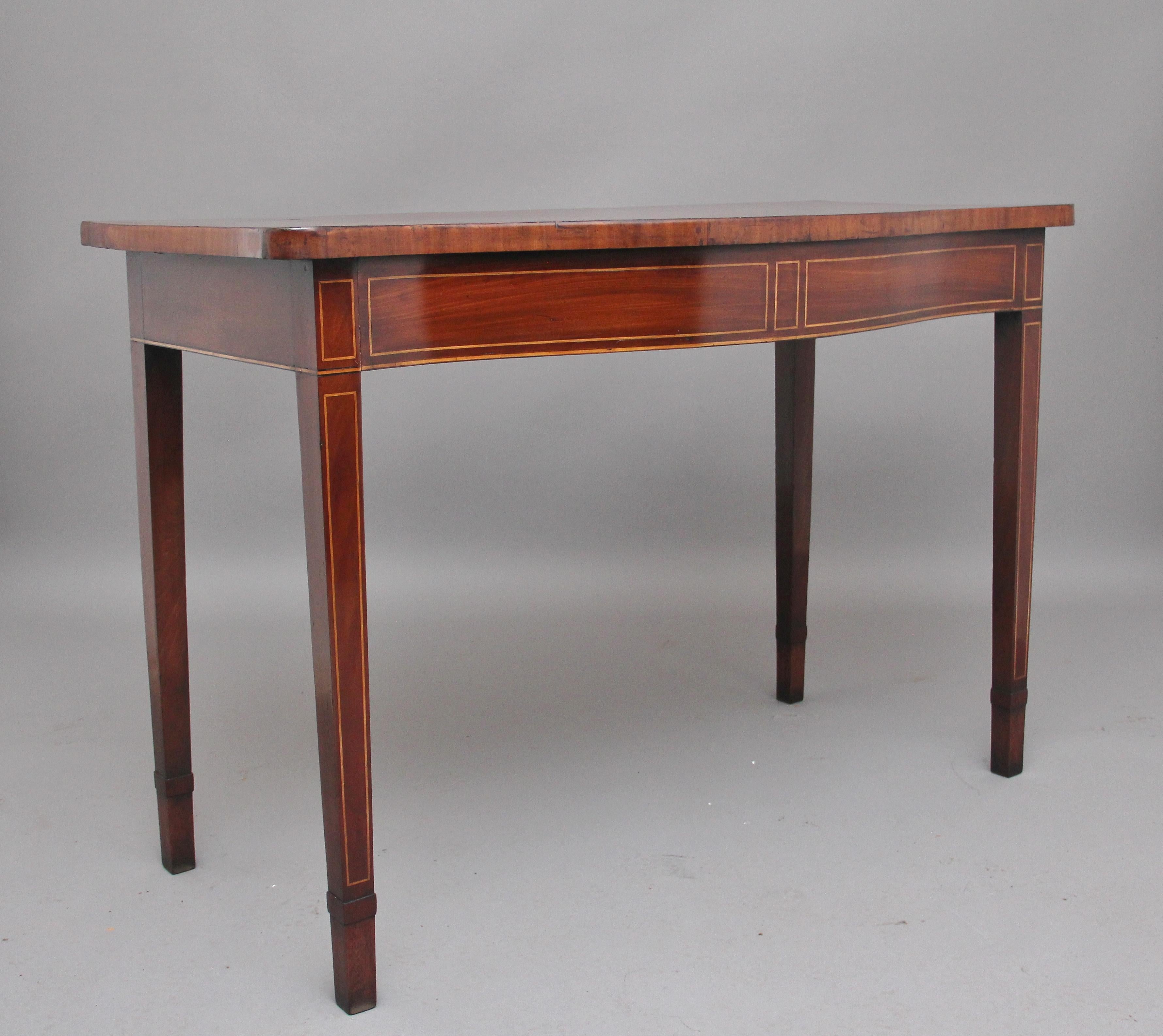 18th century mahogany inlaid serpentine serving table, the shaped crossbanded top having lovely figuration, the frieze below decorated with box wood inlay, supported on four square tapering inlaid legs. Circa 1790.
 