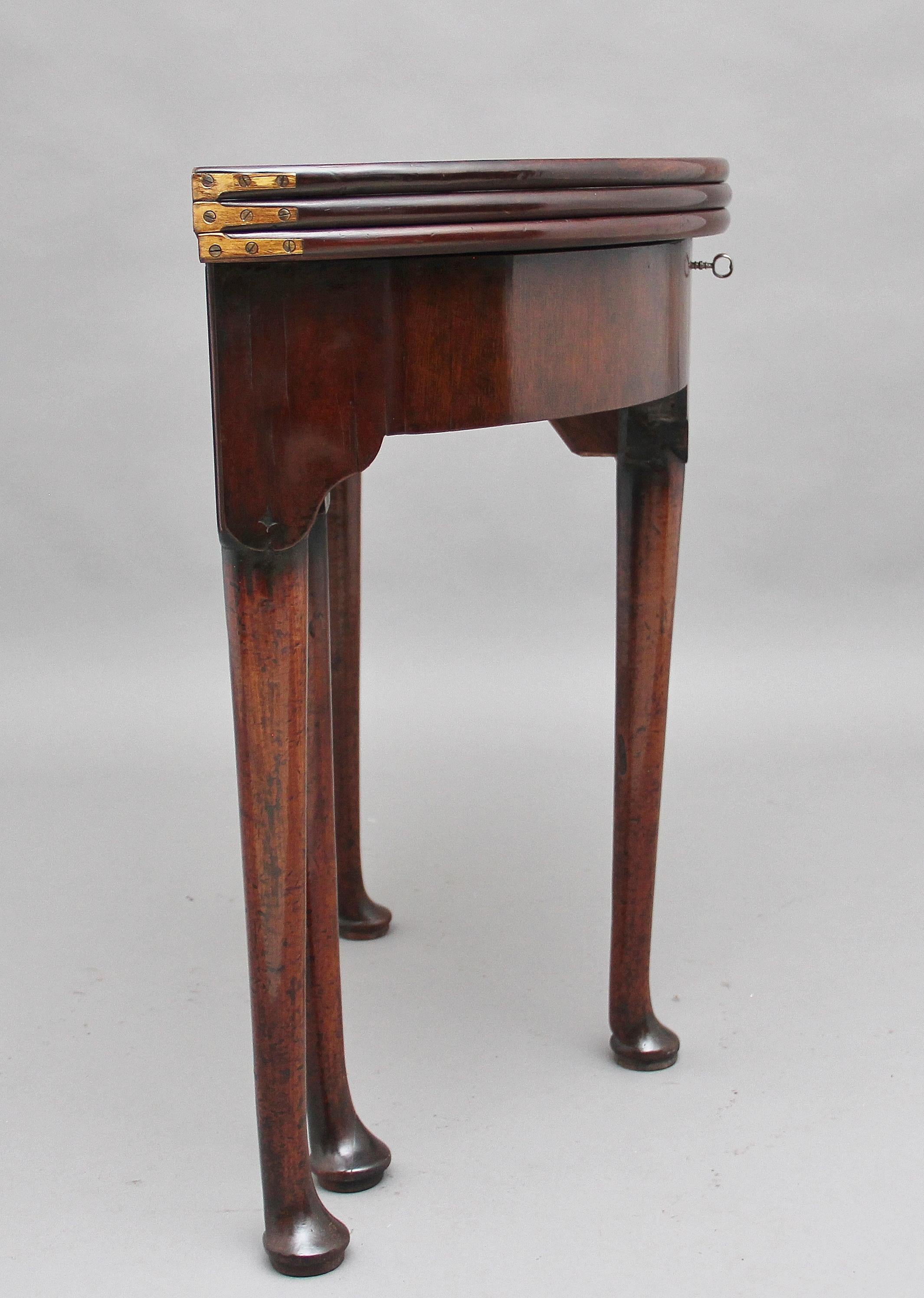 18th century triple top games table, the triple fold over top consisting of an oak lined compartment, a green baize playing surface and a solid top surface, standing on four turned legs terminating on a pad foot, circa 1760.