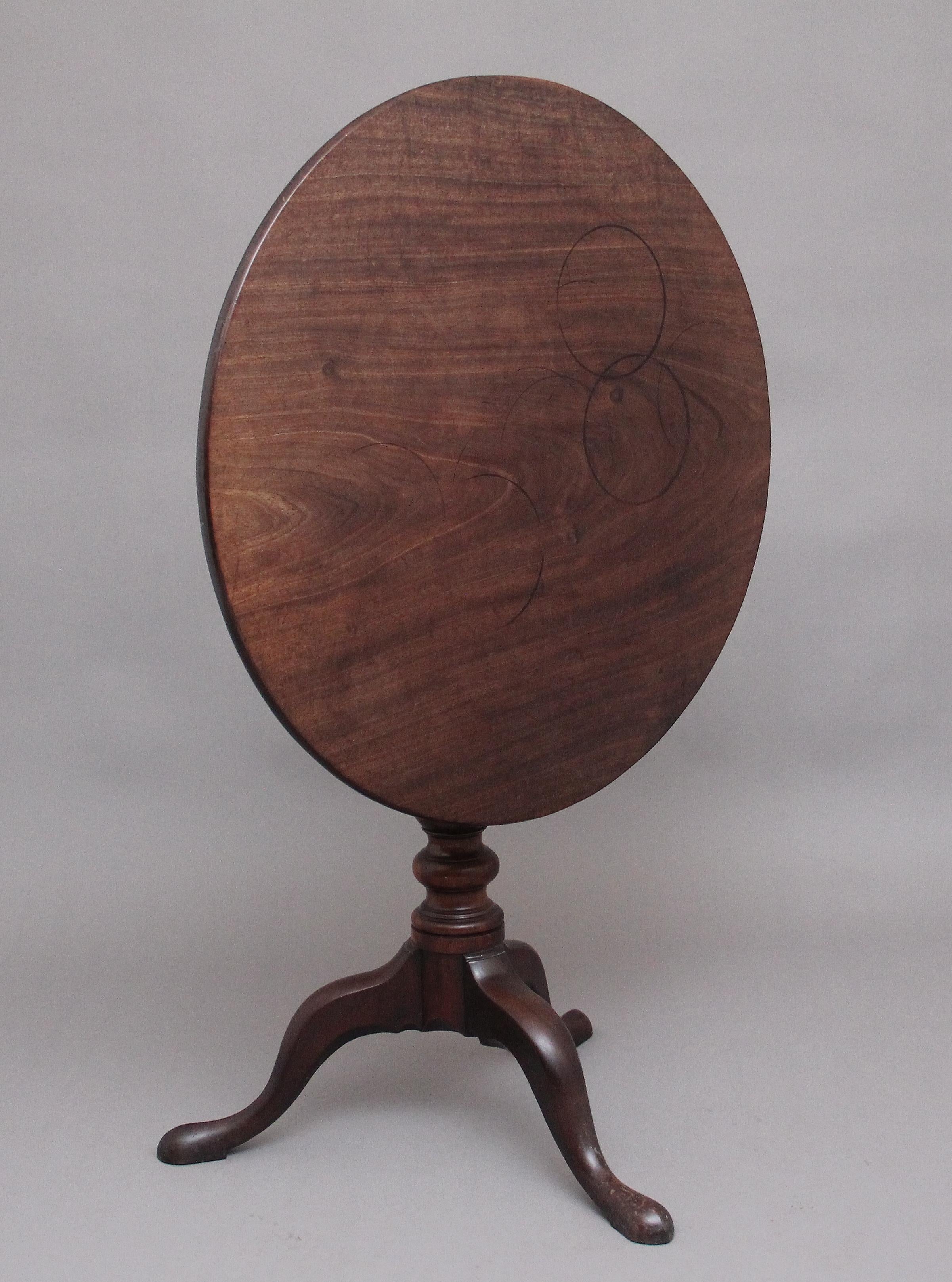 18th Century mahogany tripod table, the circular mahogany top sitting on a birdcage mount so you can turn the top without turning the base, supported on a turned column terminating with three slender shaped legs. Circa 1780.