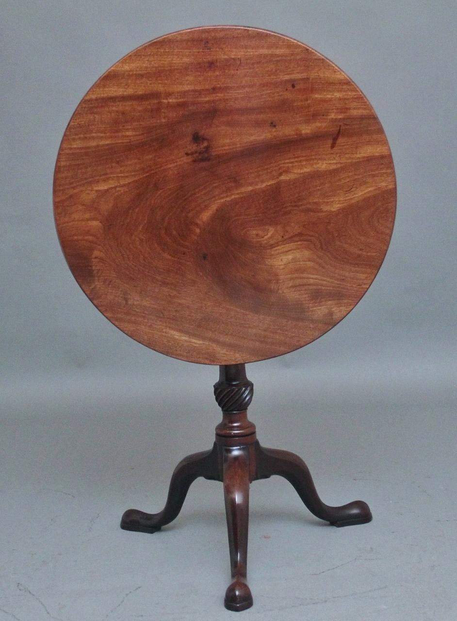 18th Century mahogany tripod / wine table, the circular mahogany top sitting on a birdcage mount so you can turn the top without turning the base, supported on a turned and carved column terminating with three slender shaped legs.  Circa 1780.
