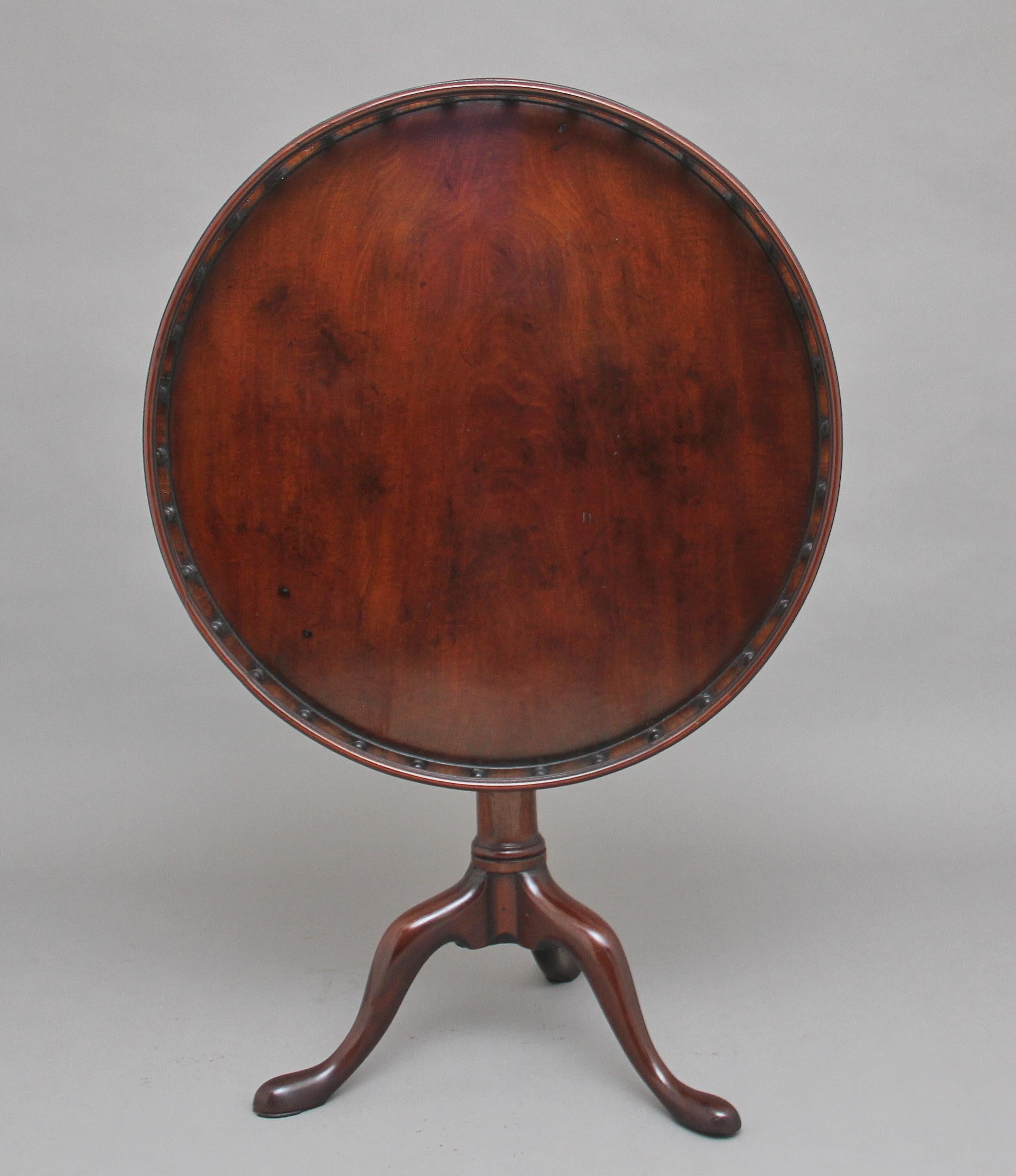 18th century mahogany tripod table having a wonderfully figured top decorated with a gallery around the edge, the gallery consisting of various turned spindles, supported on a turned column terminating with three slender shaped legs. In fantastic