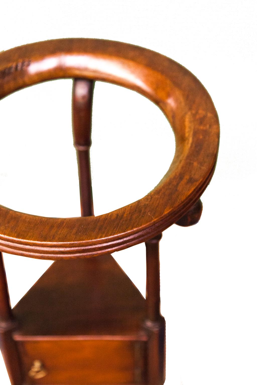 18th century mahogany wash stand, has a single door with one inside shelf. The brass handle is original, three turned columns support lower shelf, tripod base with cabriole shaped legs.
