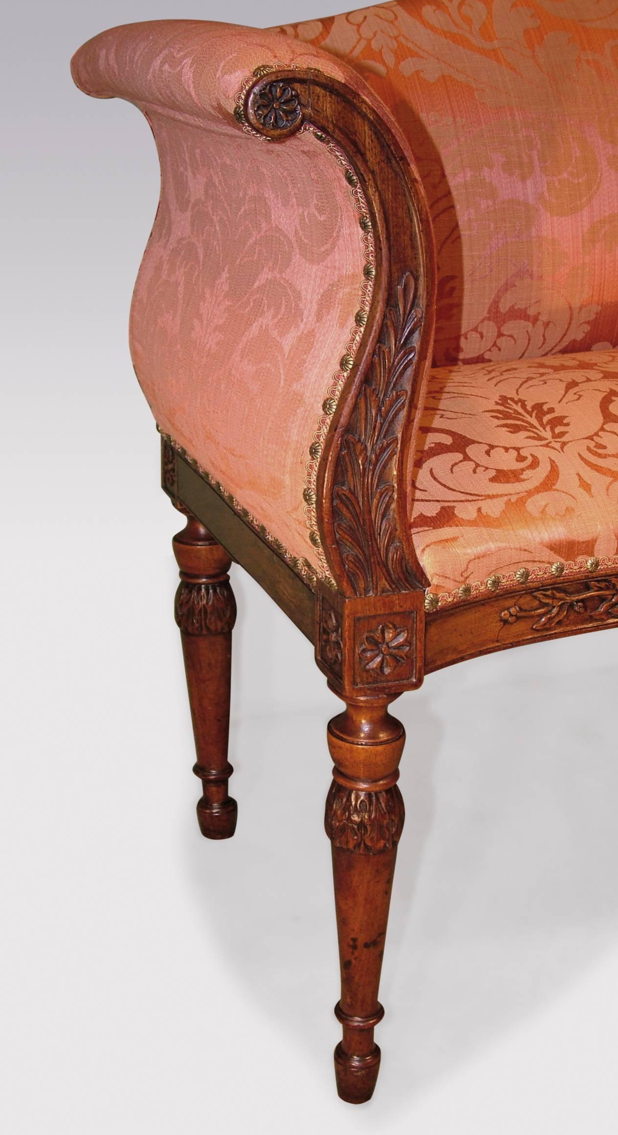 An unusual late 18th century Adam period carved mahogany window seat, having serpentine back and seat with scrolled out-swept arms, decorated with roundels, paterae and acanthus leaves, having central urn motif to the frieze, raised on leaf carved