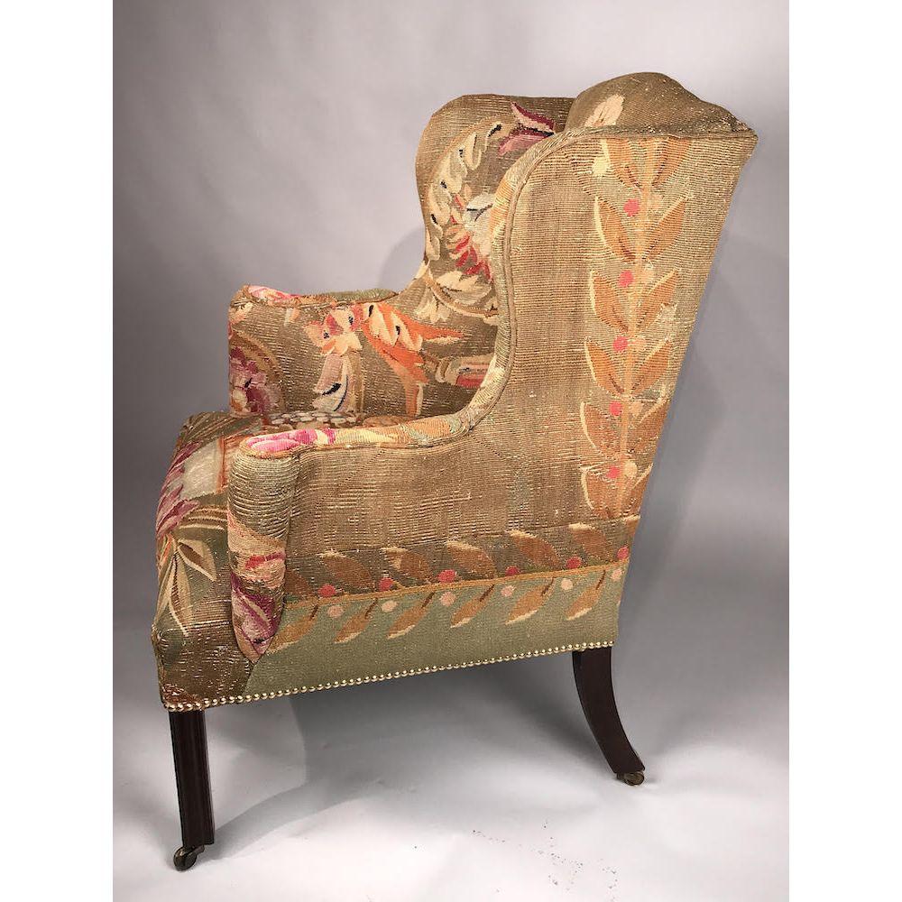 An English mid-18th century mahogany wingback armchair of good rich color and patination. 
George III period, circa 1760.

Upholstered in 18th-century Aubusson tapestry retaining its vibrant colors, and close-nailed.
Of generous proportions, this