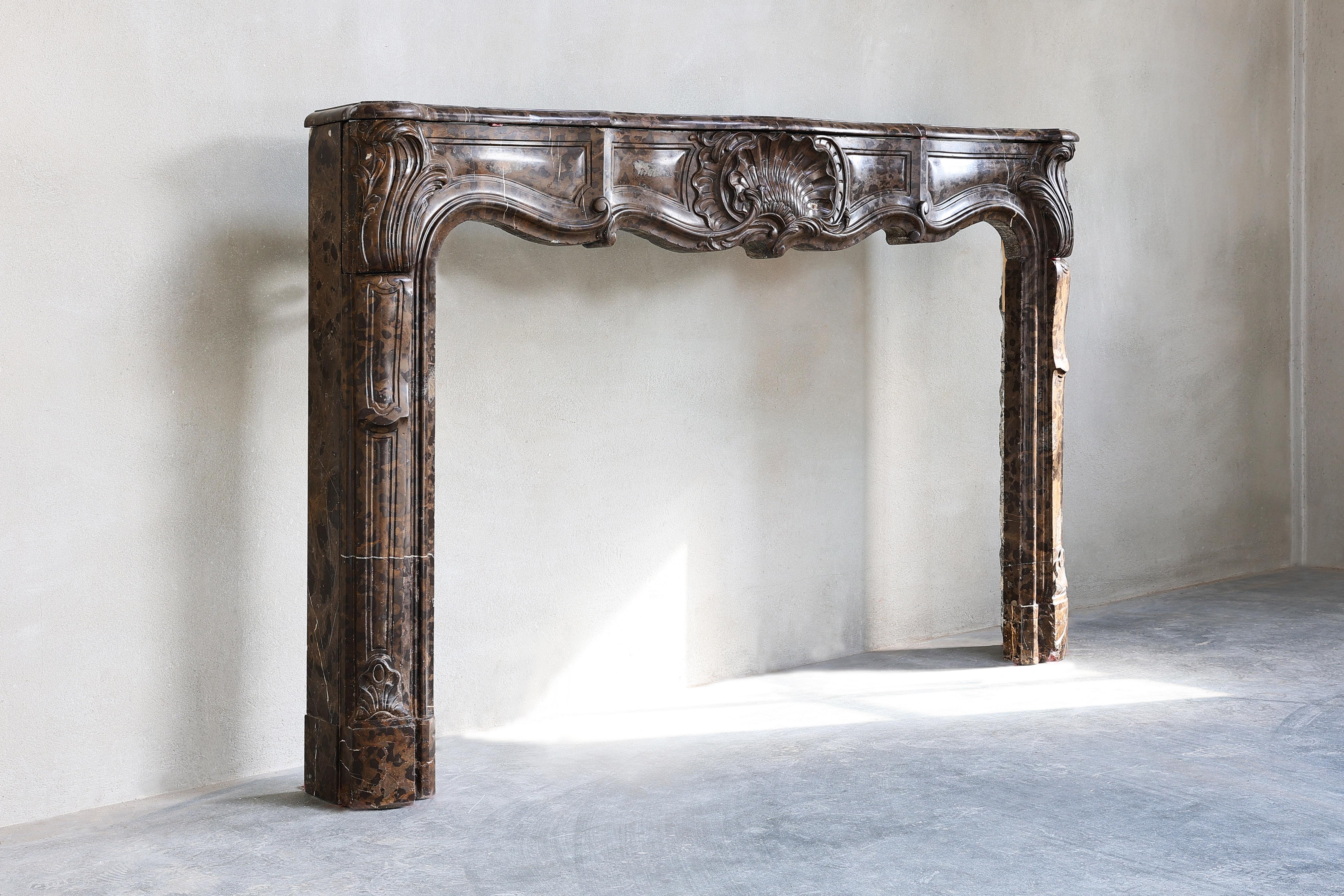 Beautiful 18th century fireplace in the style of Louis XV Rococo. This fireplace mantel has been sculptured in the warm French Stincal marble. This marble is also well known as 