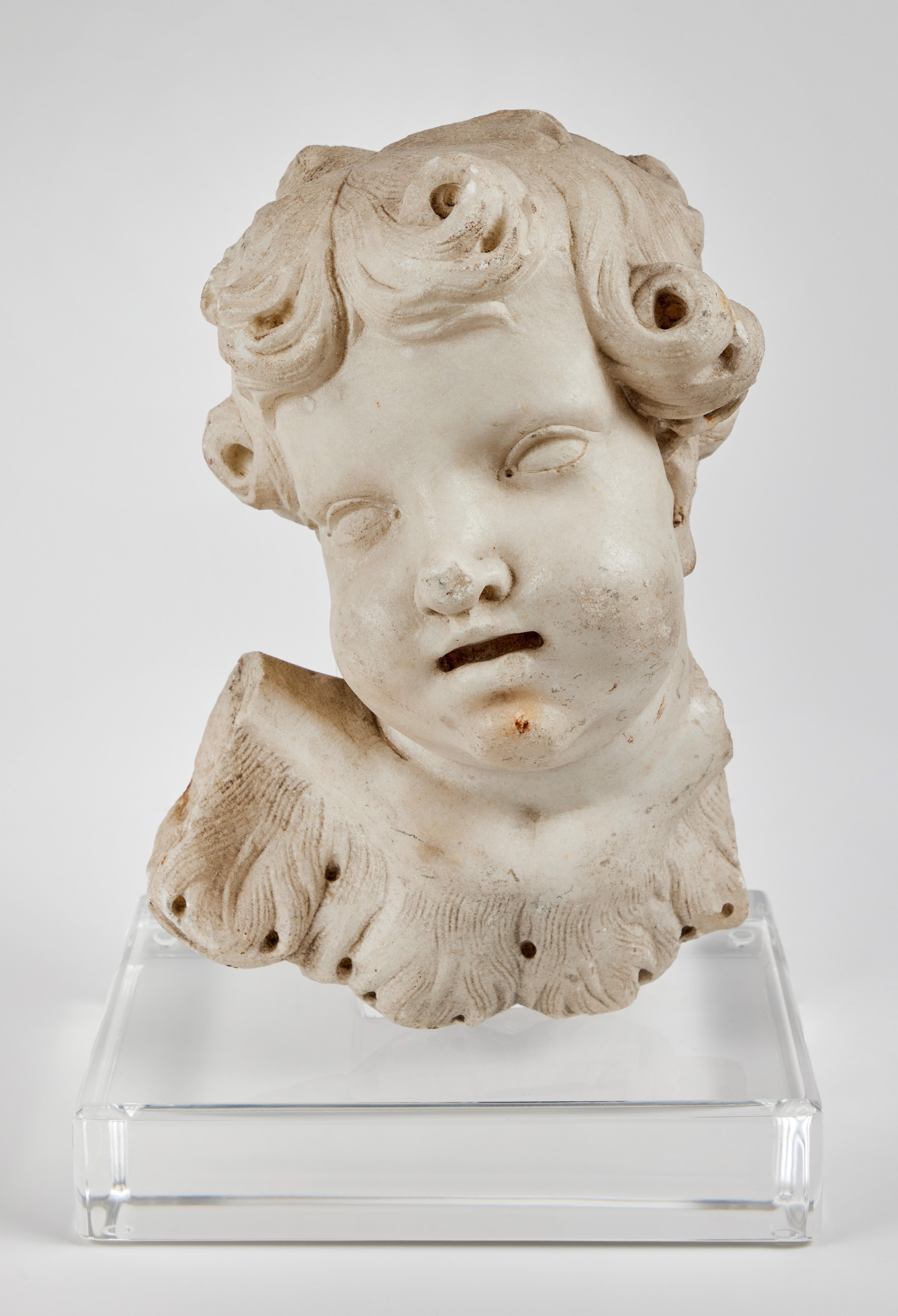  A pair of rare, early 1700’s, Roman, beautifully hand–carved, solid Carrara marble cherubim singing in adoration. Each with feather embellished robe fragments. Both mounted on custom, Lucite bases.