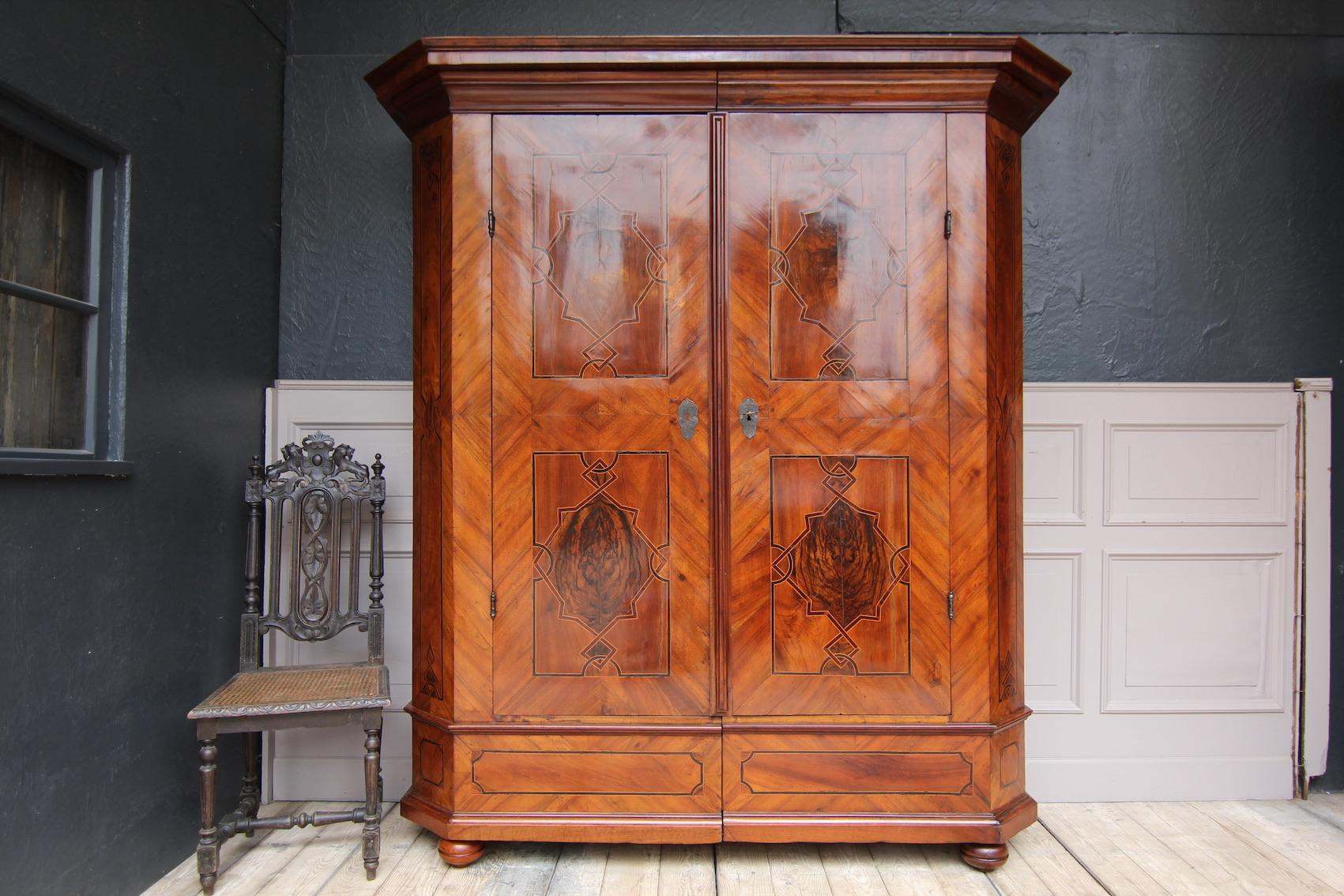 A so-called Maria Theresa cabinet (furniture type named after the Austrian empress) or Baroque hall cabinet from the 18th century.

On ball feet standing two-door coniferous corpus divisible by means of wedge connection with profiled plinth and