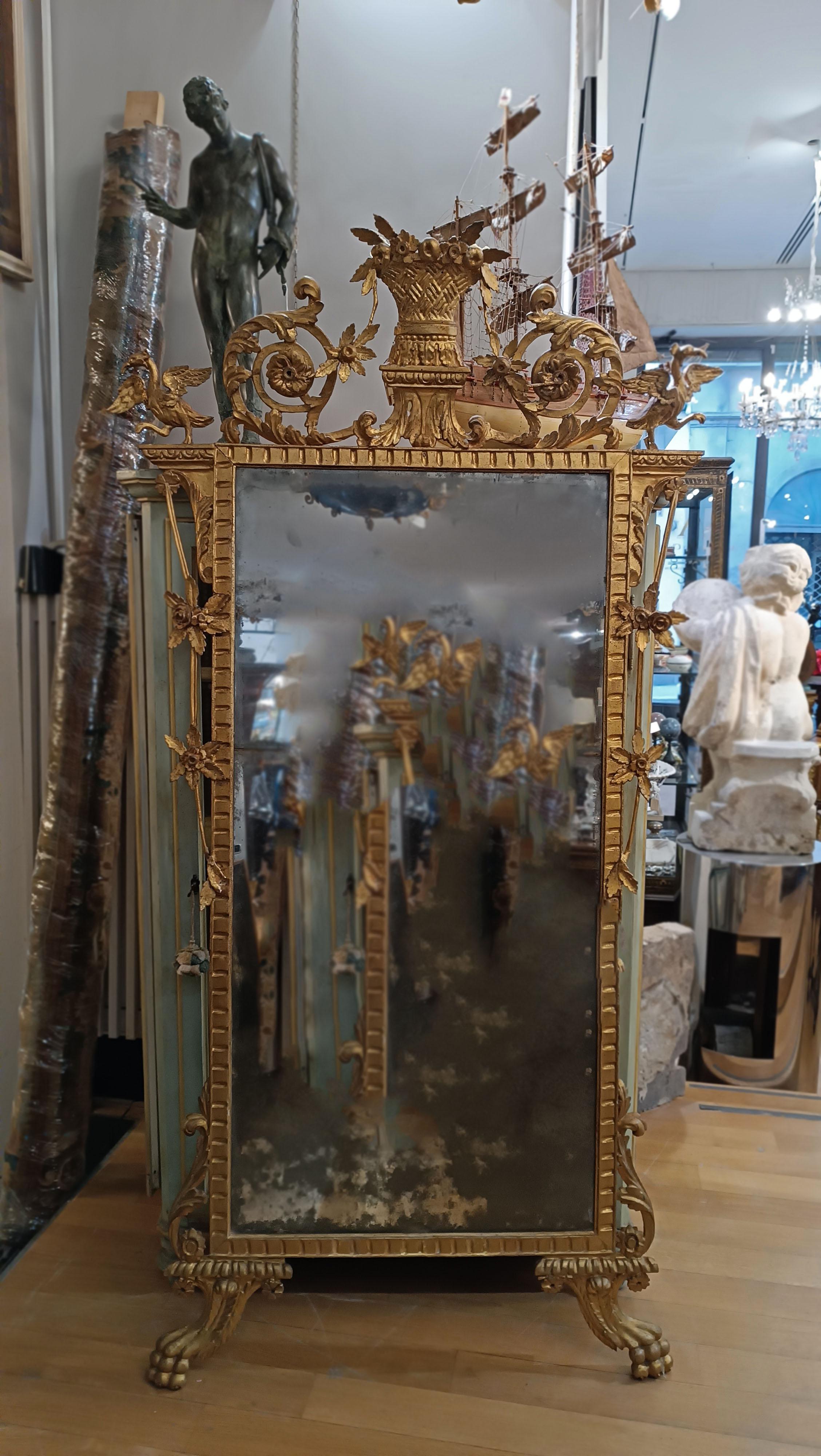 Elegant mirror made of carved pine wood and subsequently gilded with pure gold leaf. Made in Tuscany, probably in Lucca, its style is clearly Neoclassical and dates back to the end of the 18th century. The mirrors present are original and the rear
