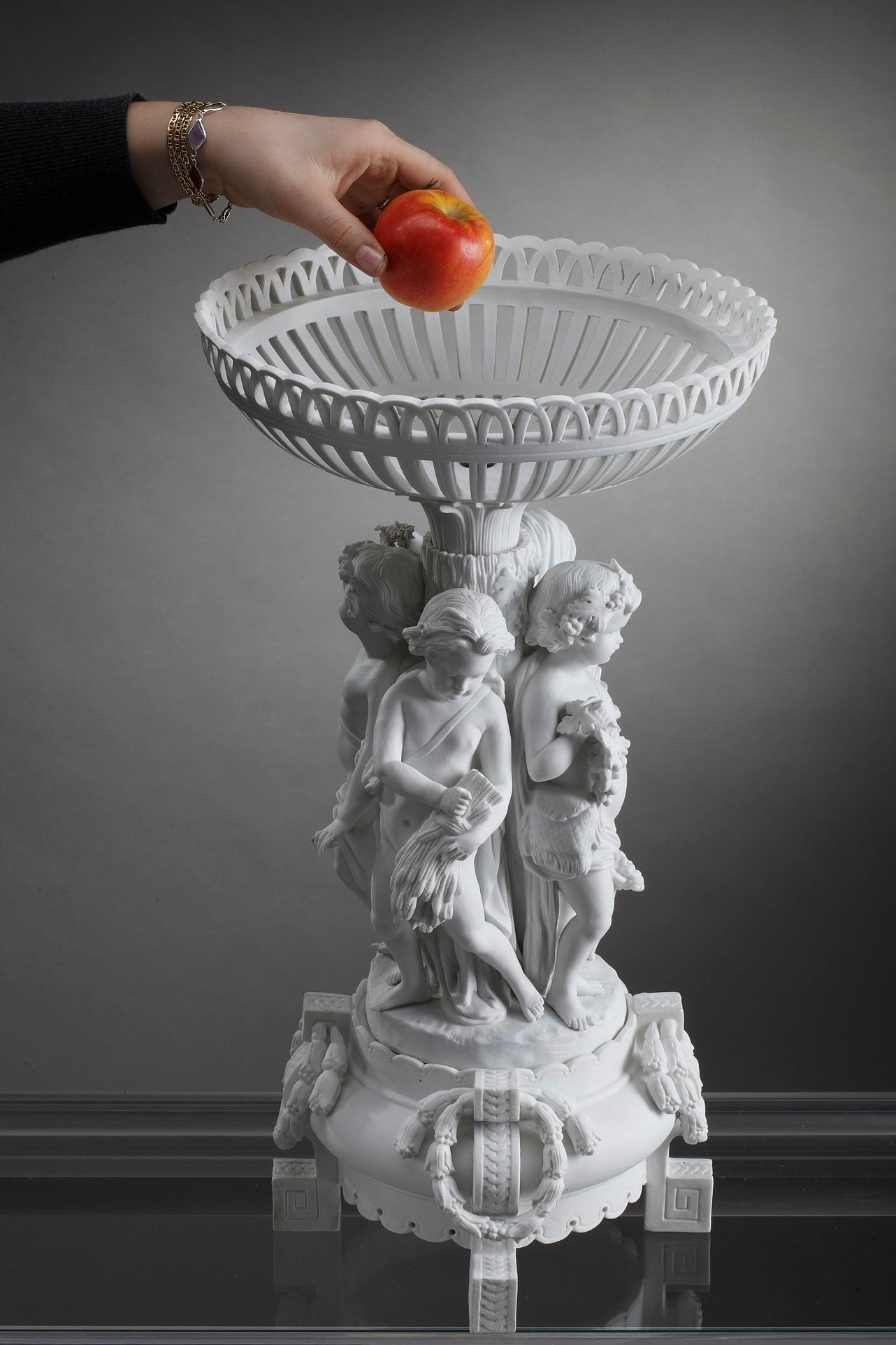 This large Meissen centerpiece crafted of biscuit exhibits the firm’s artistry in Neoclassical aesthetic. It features an allegorical group composed of four children detailing the Four Seasons: Spring wears a wreath and holds flowers, Summer has a