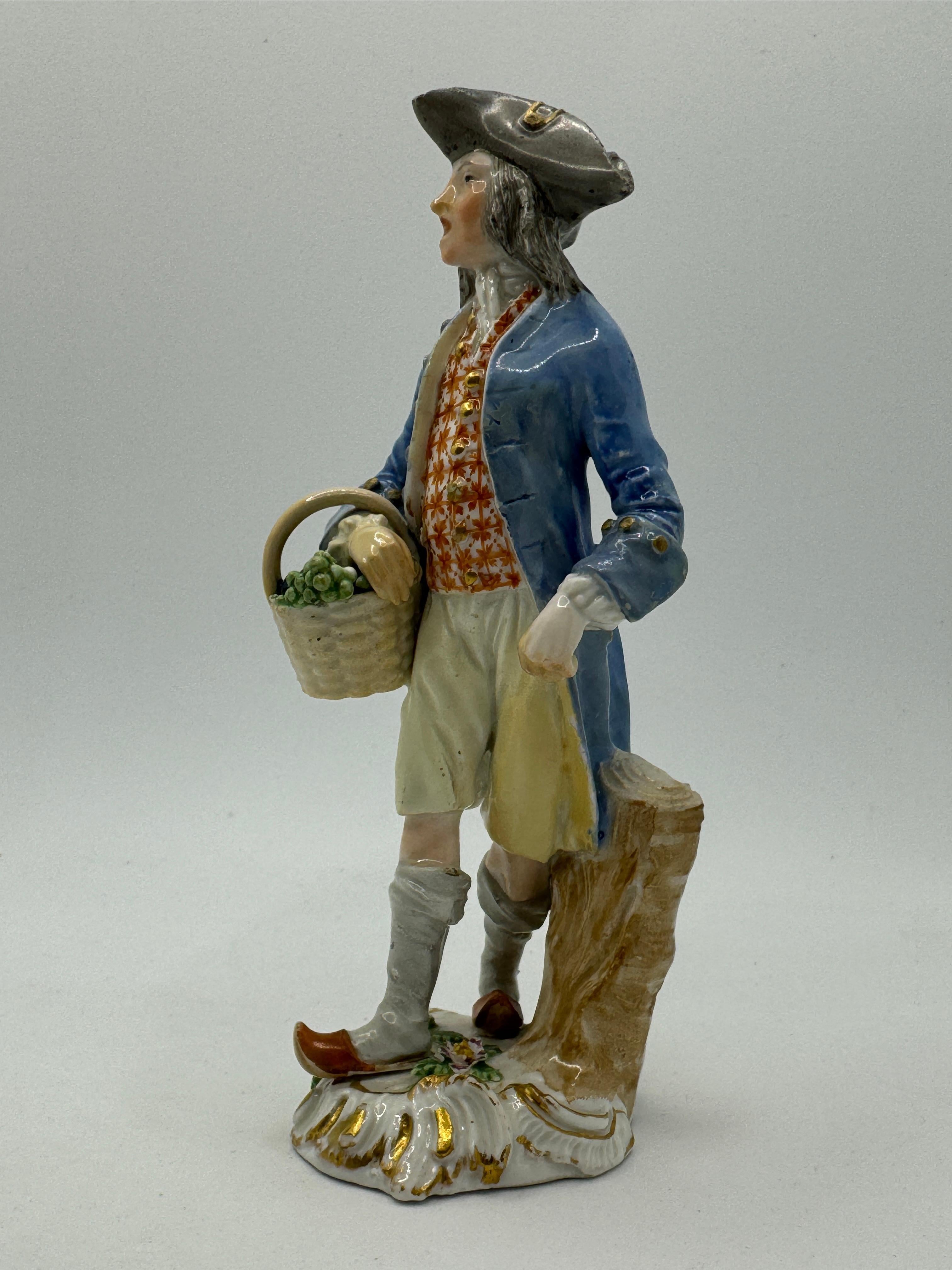 Figura de Meissen del siglo XVIII 'Figura de comerciante callejero vendiendo uvas'  

Modelada por Peter Reinicke como parte del grupo de figuras 