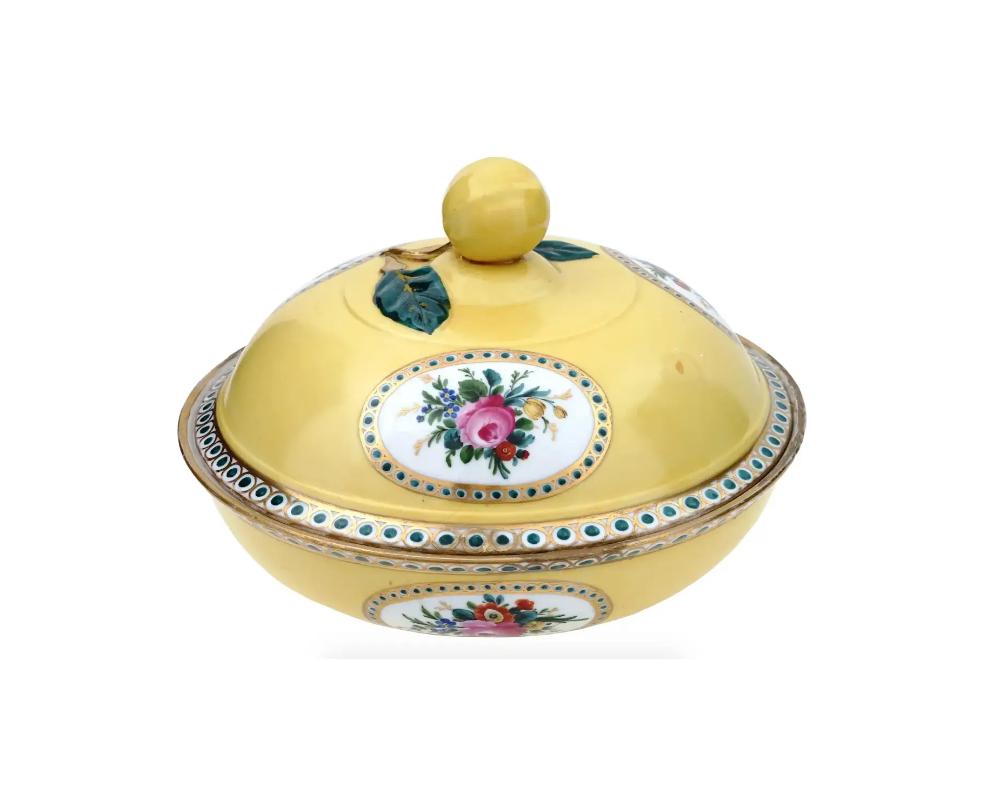 A German Meissen yellow porcelain candy bowl with a figural knob. The exterior of the bowl is delicately adorned with oval shaped medallions with images of bouquets of flowers, geometrical ornaments on borders. The know of the cover is shaped as a