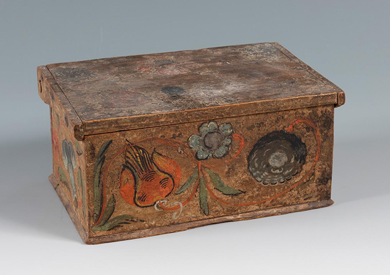 Mexican chest. New Spain, 18th century.
In polychrome wood.
Slight paint losses on the lid.
Measurements: 7 x 16 x 6.5 cm.
Wooden chest from the viceregal period, hand-polychromed on each of its sides with large flowers and juicy fruit. From the