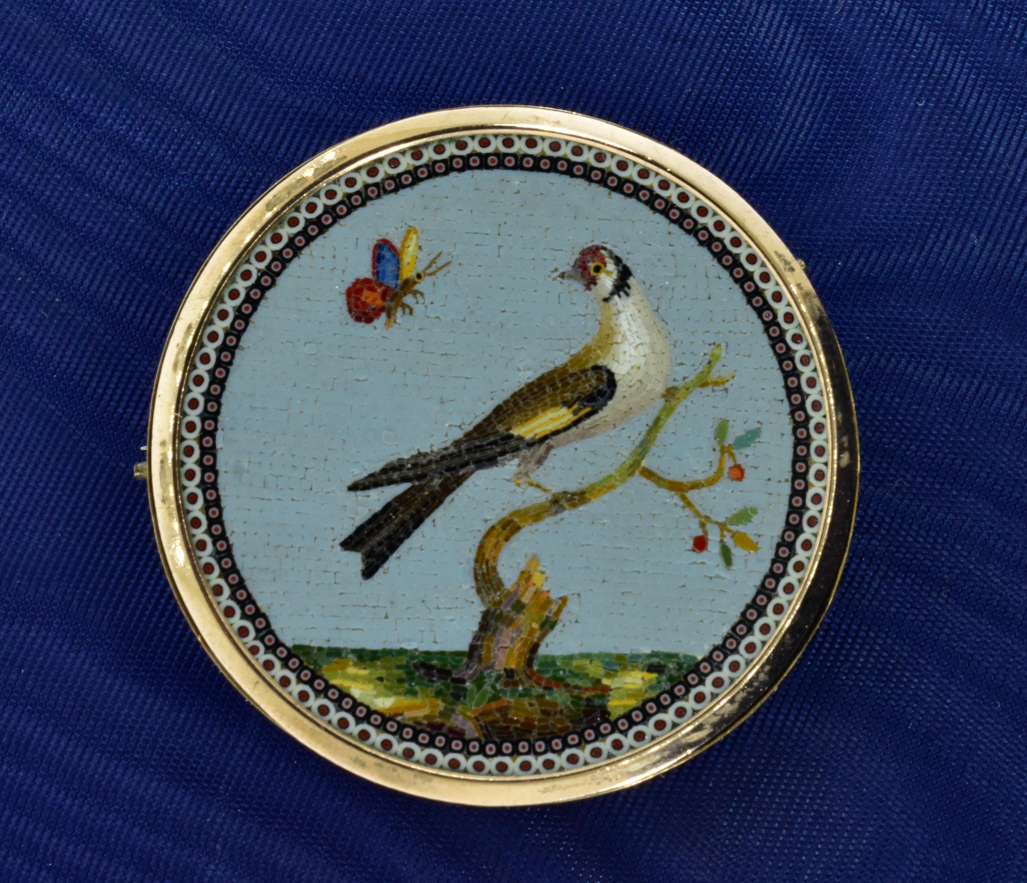 Broche en micro-mosaïque de la fin du XVIIIe siècle ou du début du XIXe siècle représentant un oiseau sur une branche qui regarde une abeille s'approcher. La mosaïque est en bon état et se trouve dans un cadre en or. La tige et le fermoir ont été