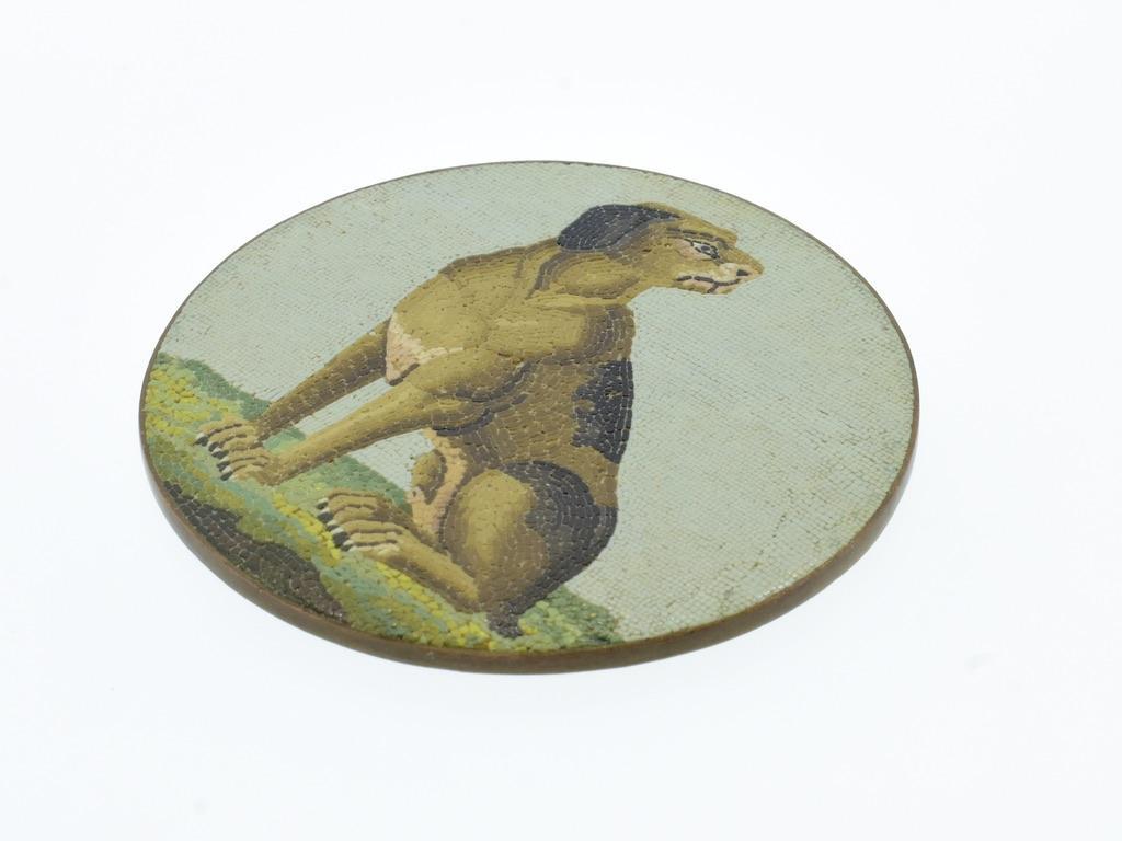 18th century micromosaic plaque of a dog looking right.  The sparse but interesting vegetation in the foreground, the light blue background set with horizontal oblong or square tesserae, each tessera comprising one color, and a low ground line are