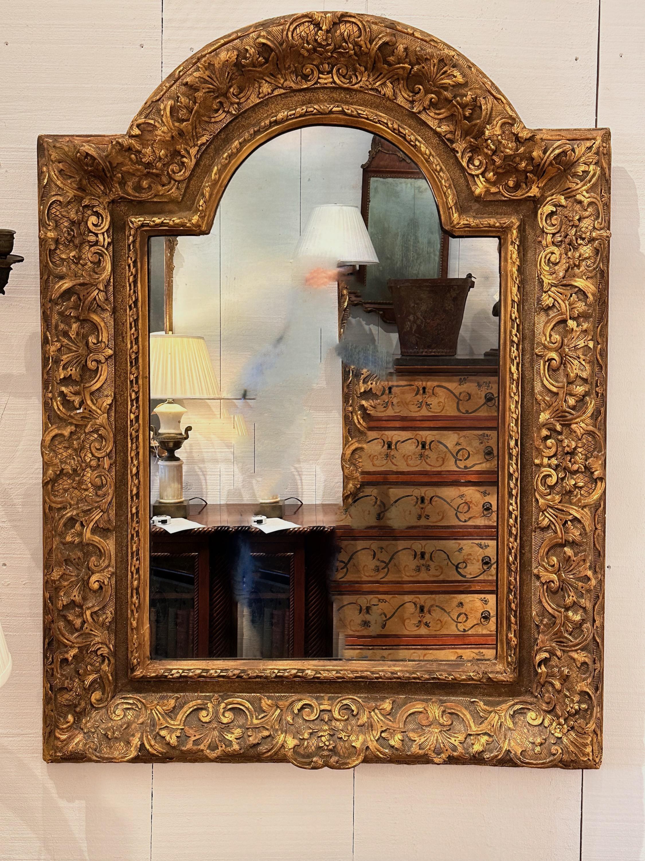 A heavily carved and gilded mirror. Ready to hang