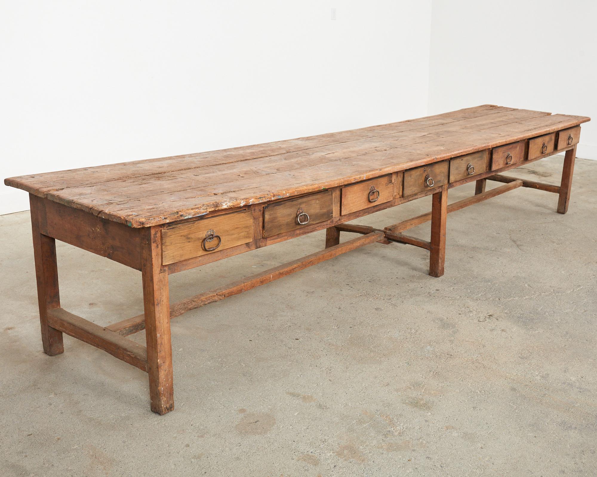 Rare authentic 18th century monumental French drapers trestle table or store display featuring 16 work drawers. This massive work table was used in a mercery or Habadashery by cloth merchants or drapers to cut and sew long bolts of fabric. The