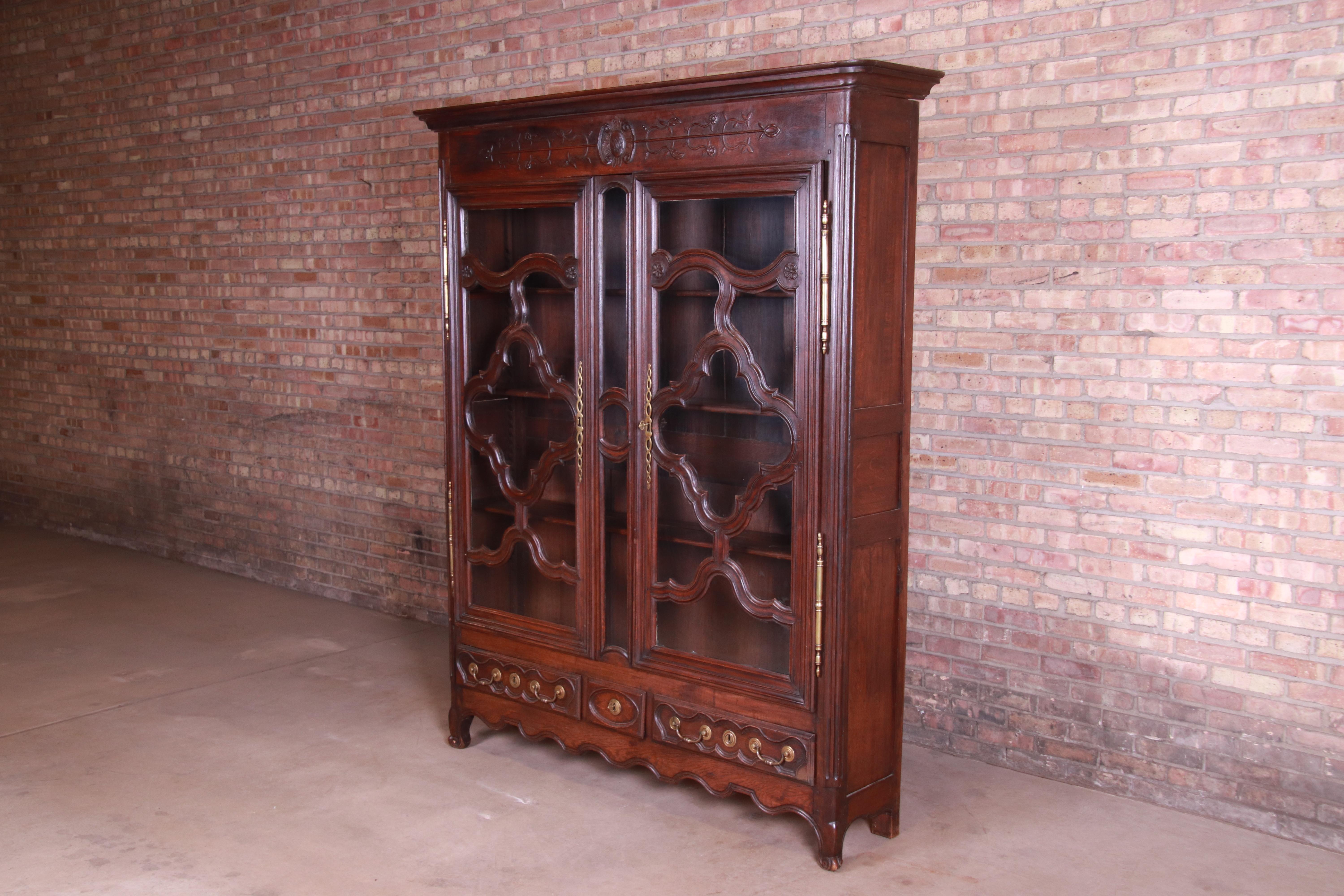 An exceptional monumental French Provincial Louis XV period armoire, linen press, or bookcase

France, 18th century

Ornate carved oak with brass hardware and original glass fronts. Original keys are included.

Measures: 68.75