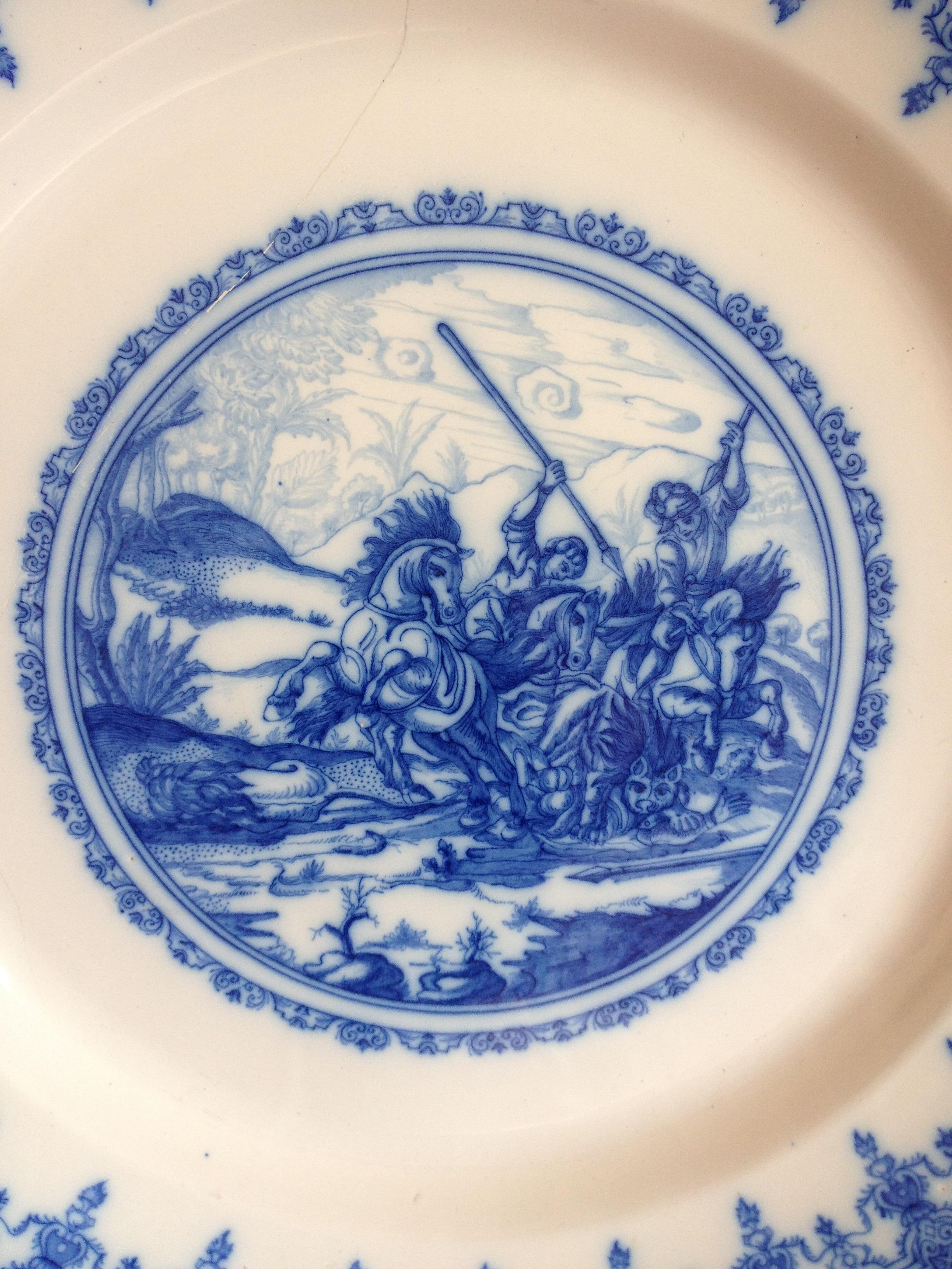 Assiette décorative de style Delft ou chargeur de style Chinoiserie en bleu et blanc du 18e siècle. 

Cette belle assiette ancienne est en faïence de Moustier (France), peinte à la main, décorée en camaïeu bleu, dans une réserve circulaire composée