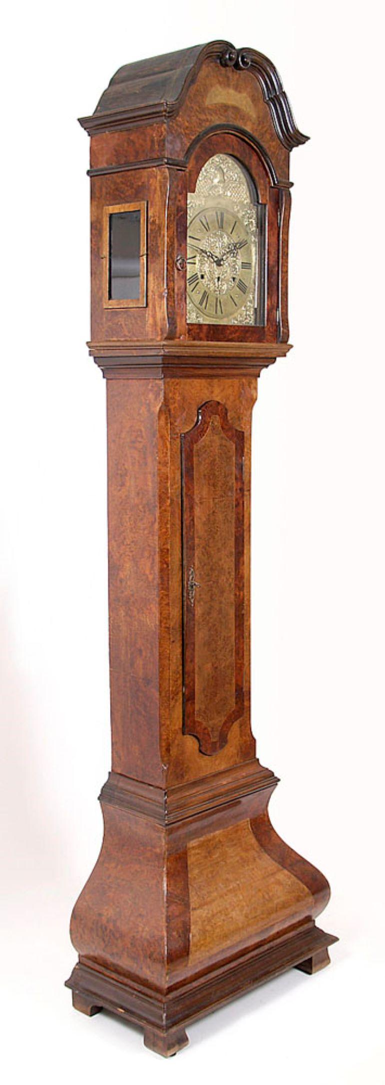Grandfather clock, floor-type long case, one-piece, in a rectangular cabinet, with a separate, wider base, curved at the bottom, supported on four legs, front block shaped, rear console legs.
Stem with full, lockable doors. A hood with a glass door