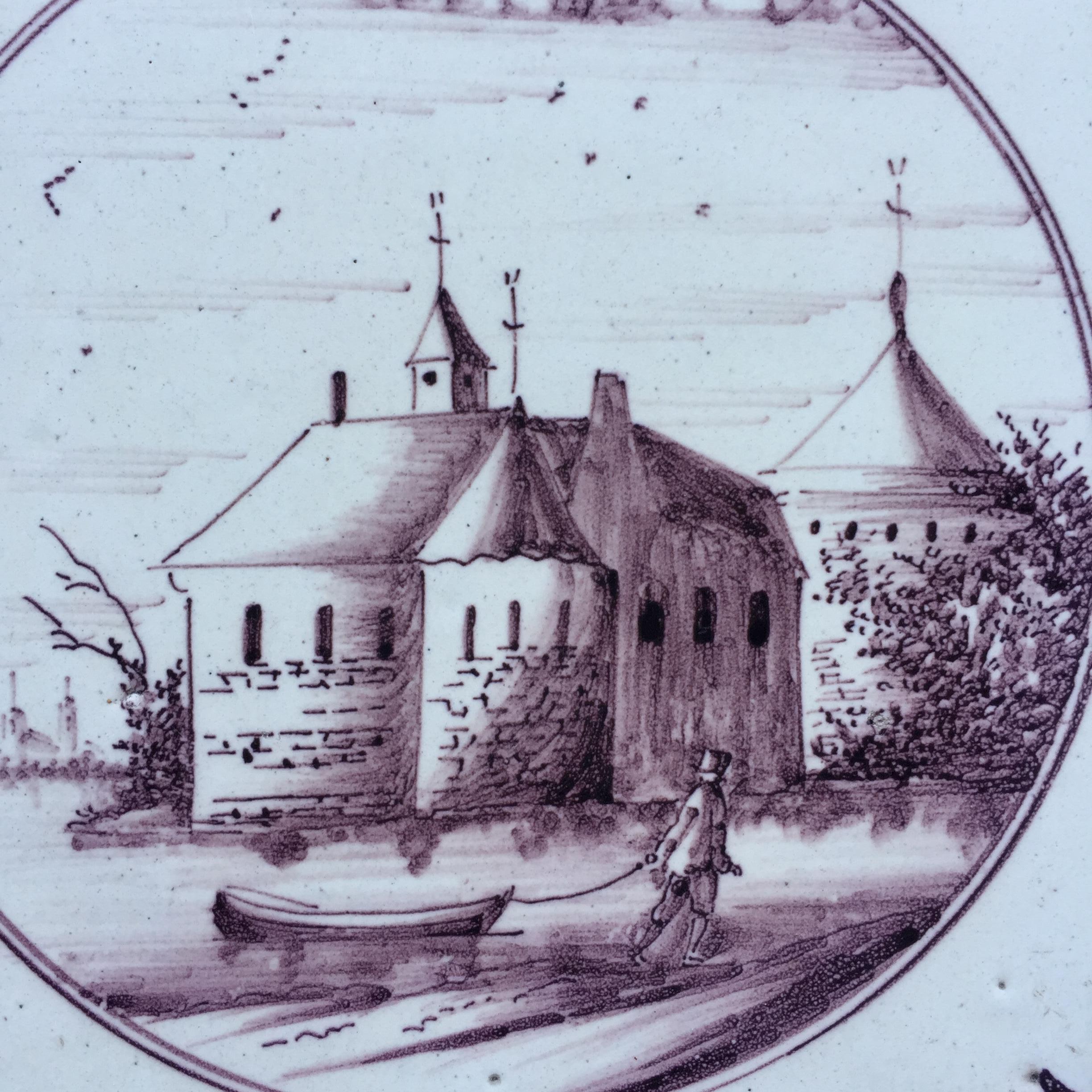 The Netherlands
Amsterdam
1800 – 1825

An unusual landscape tile with the decoration of a castle at a river with in the front a man with a boat, painted within a circle. With a very small corner decoration of a quarter of a star.

The tile is in