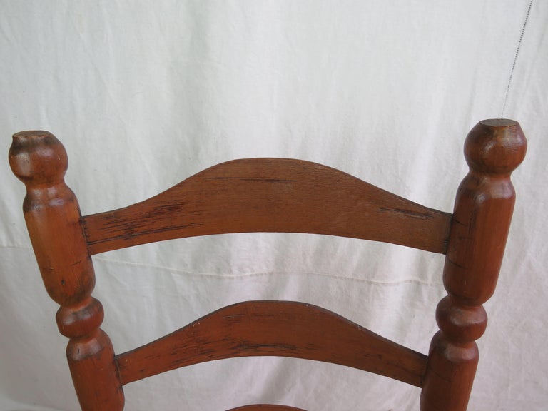 18th century nantucket fireside ladder back side chair, circa 1780 or earlier, having characteristic ball finials atop sausage and ball turned standards, holding three shaped back slats, above a rush seat, raised on short turned legs braced by dowel