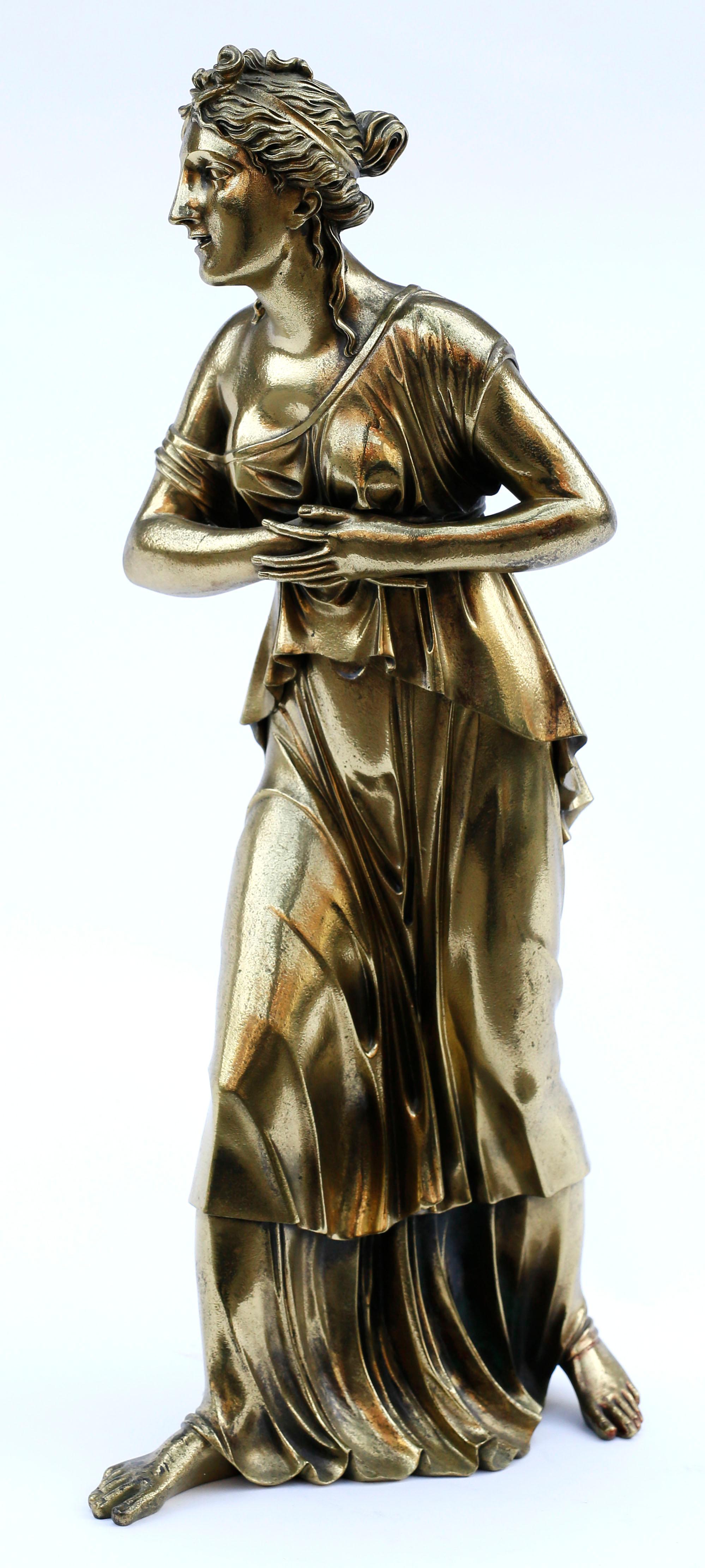 A masterful large classical statue in cast bronze of a beautiful young woman in stride wearing a flowing ionic chiton. The exquisite casting of the details of the woman's hair and deeply folded robes mark the piece as extraordinary from both a
